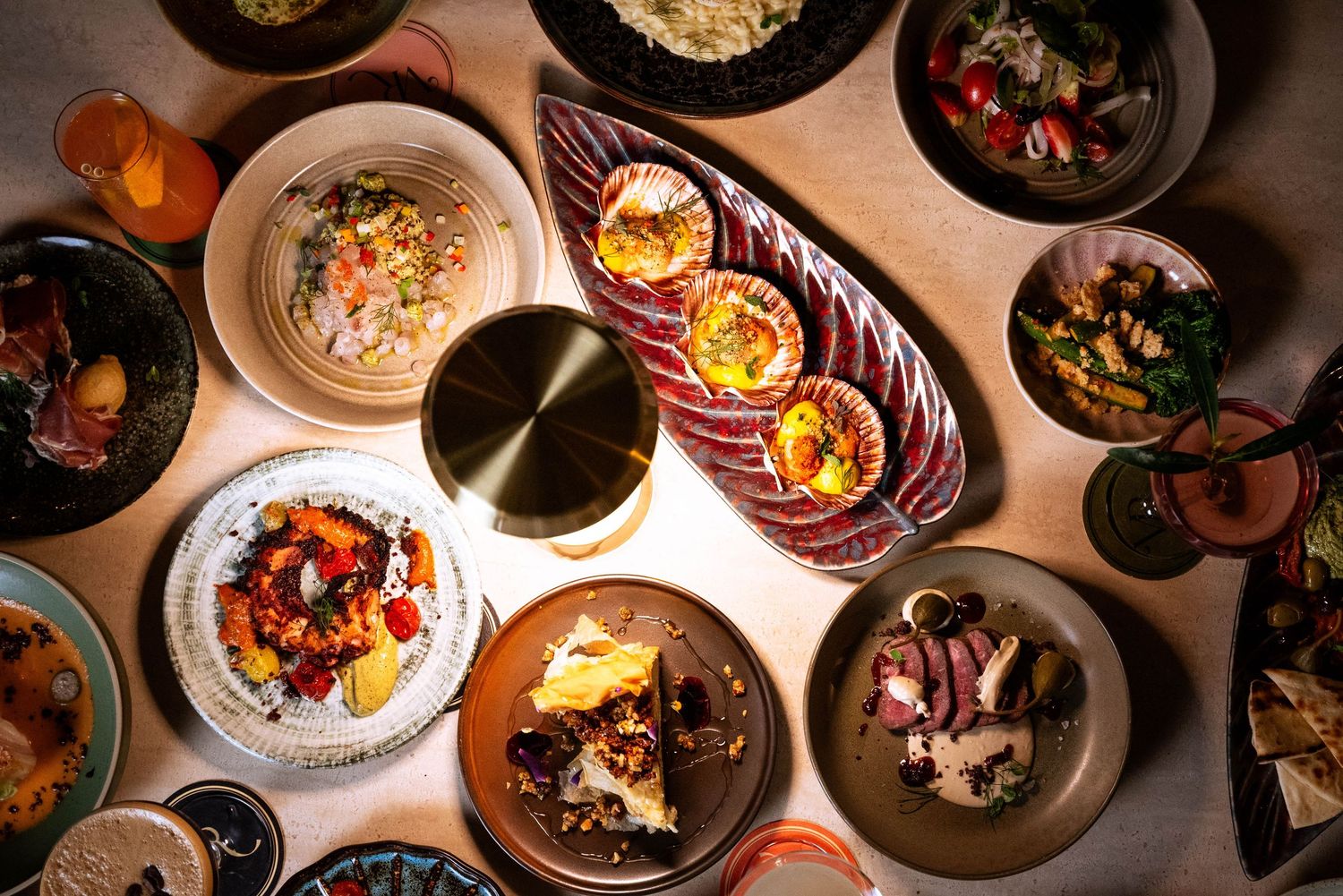 Flat lay at night with shared dishes, cairns