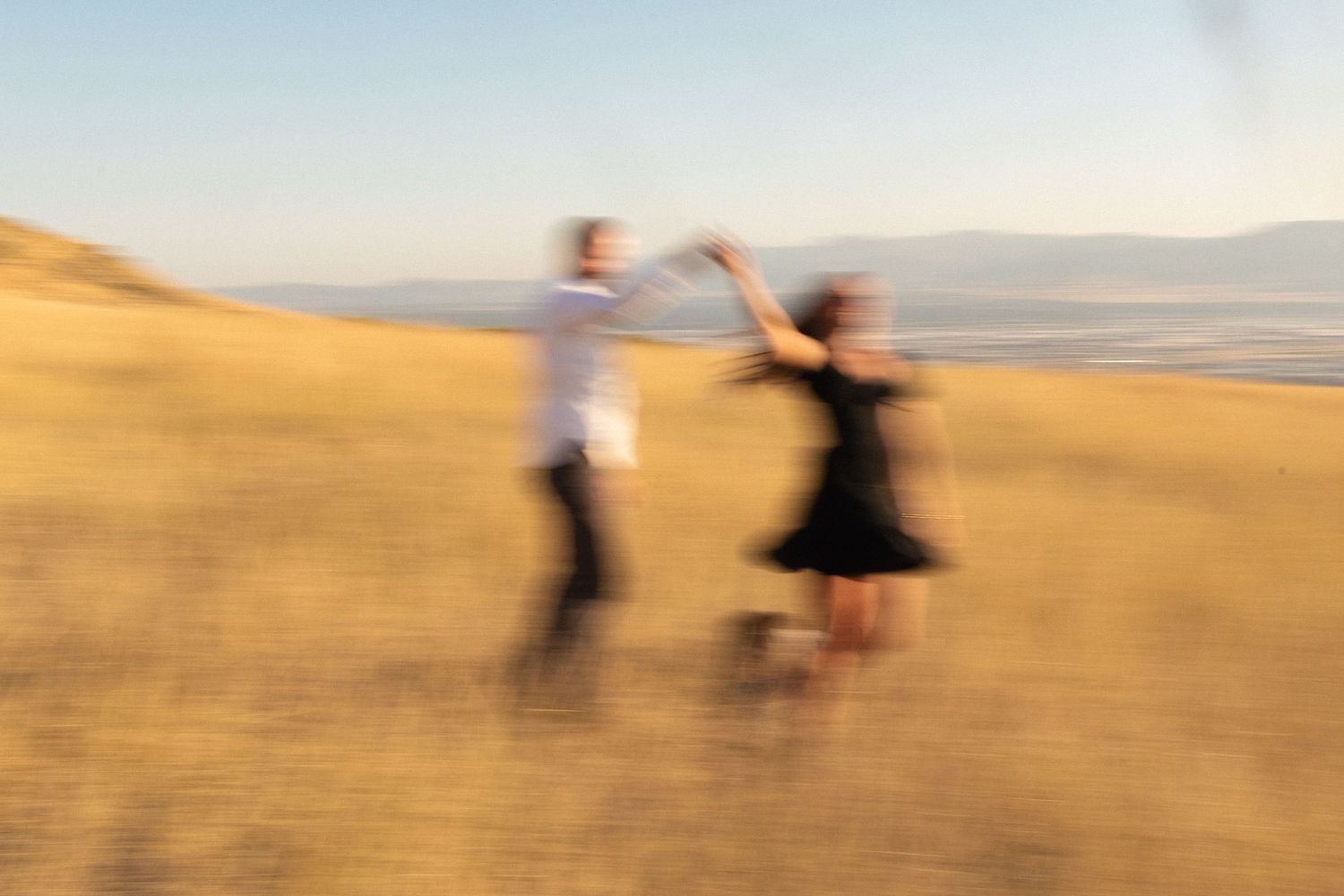 A blurry photo of a couple dancing during their baby announcement photo session in Tunnel Springs Park, Salt Lake City, Utah.
