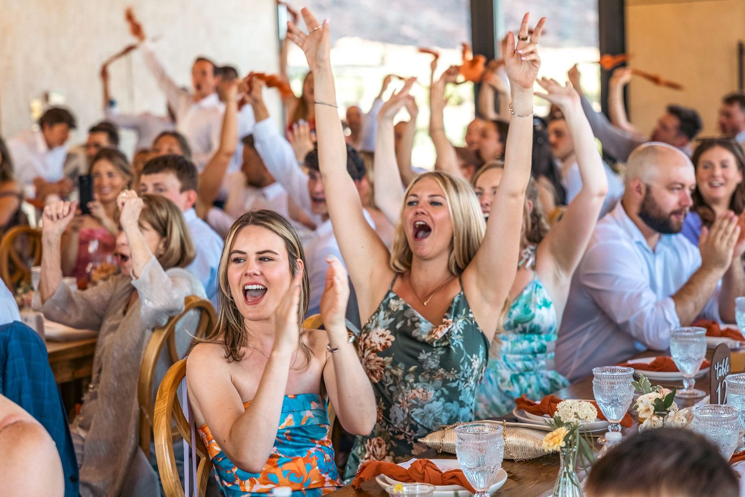 People cheering during wedding dinner.
