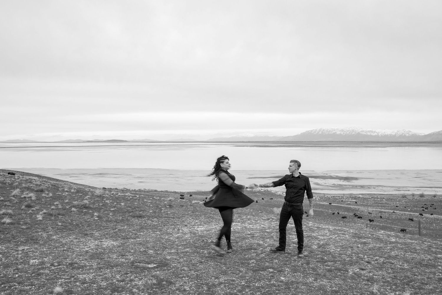 A black and white photo of a couple dancing by the Great Salt Lake on Antelope Island.