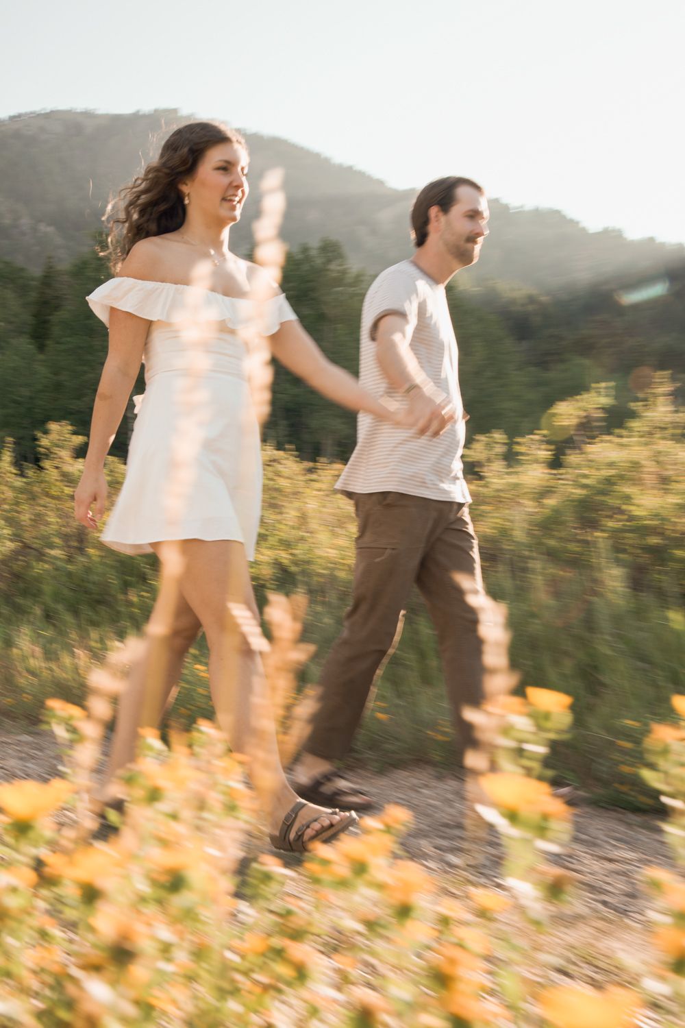 A couple walking down a dirt road in Snowbasin, Utah.