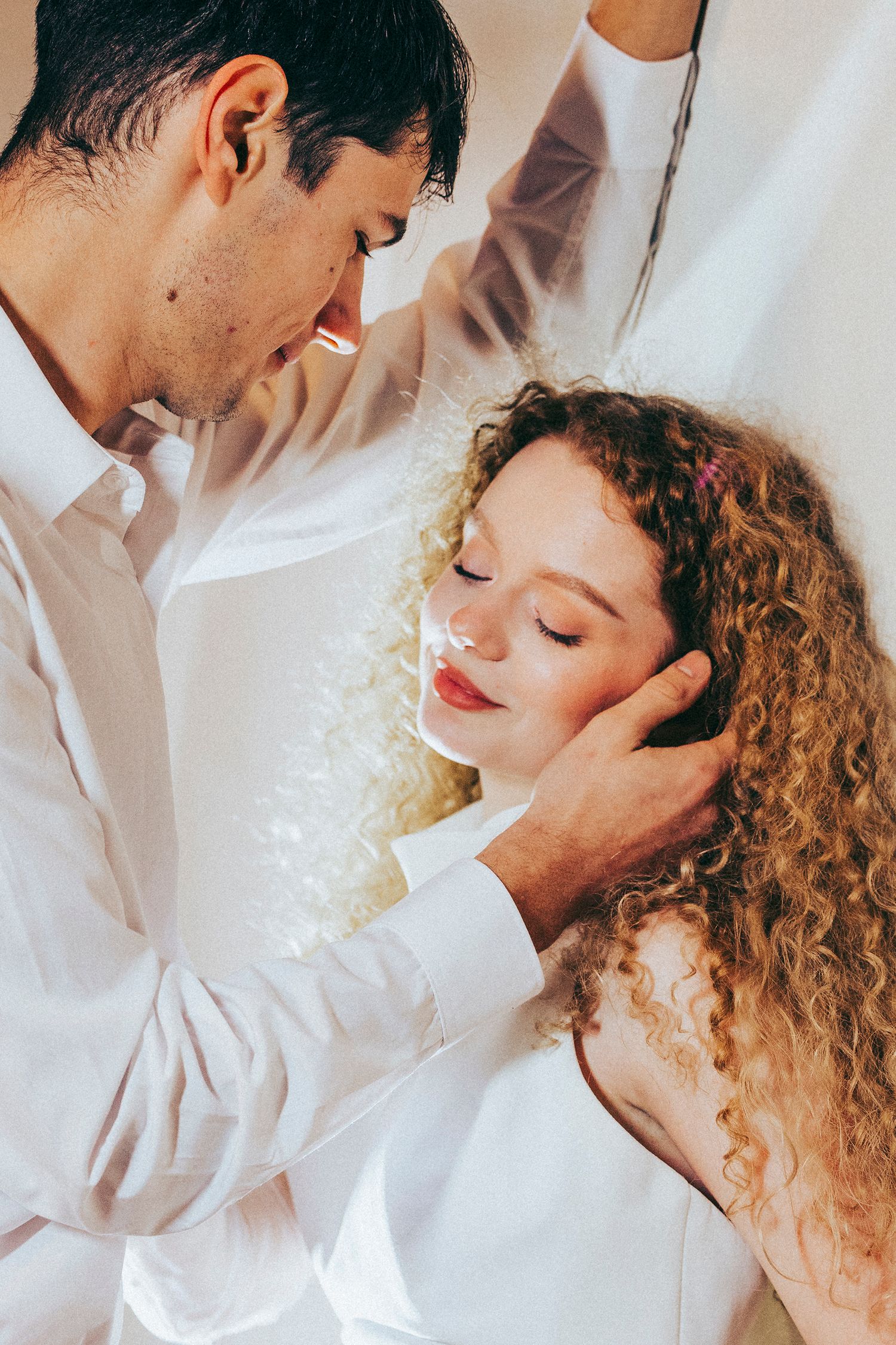 Romantic couple in white clothing share intimate moments in a series of tender close-up photographs.