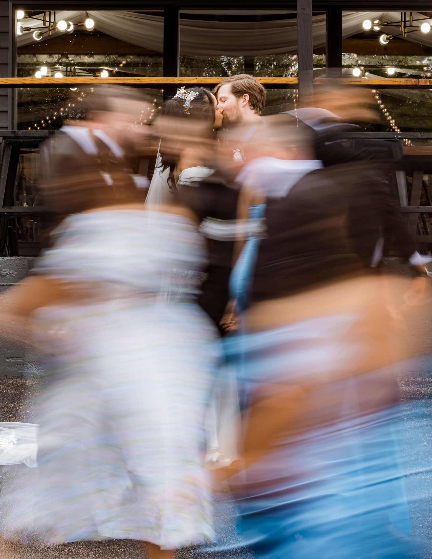 A motion blur photograph captures dancers in flowing dresses spinning during a performance on stage.