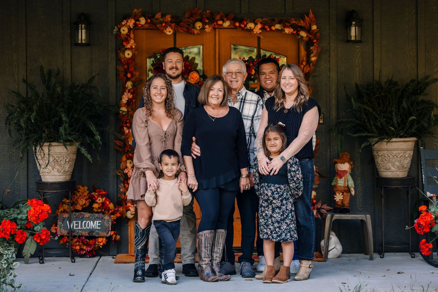 A festive outdoor porch decorated with garland and holiday lights during a family photo session.