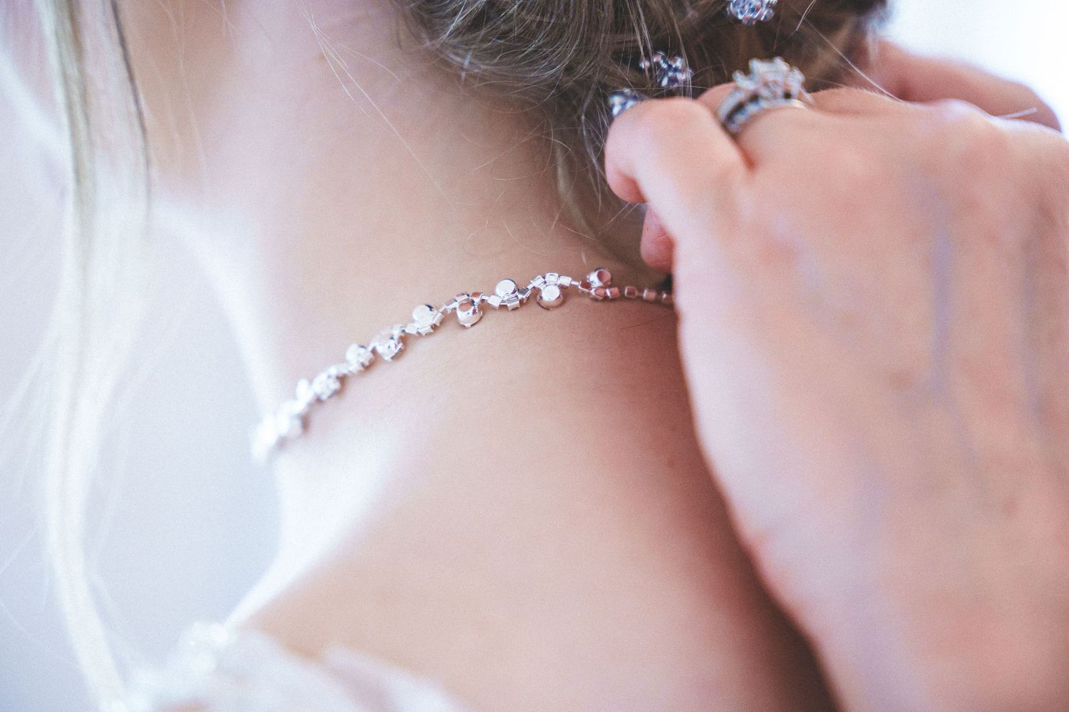 Two people share an intimate embrace during an emotional wedding moment in a bright white setting.