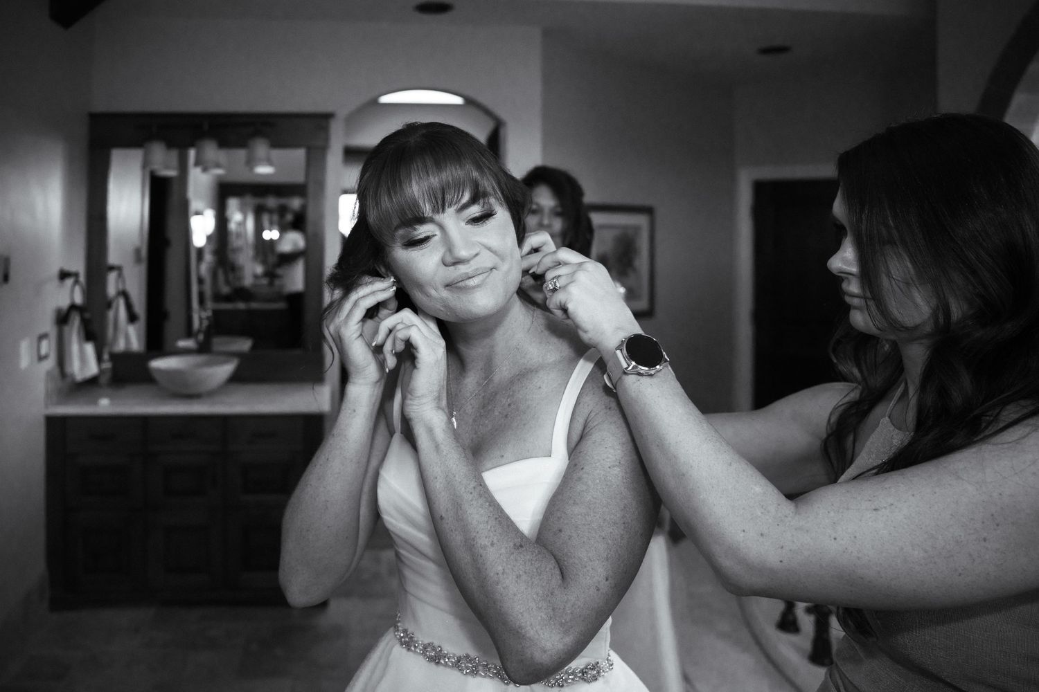 A behind the scenes moment of bridal preparation with a bride getting ready and her hair being styled before the ceremony.