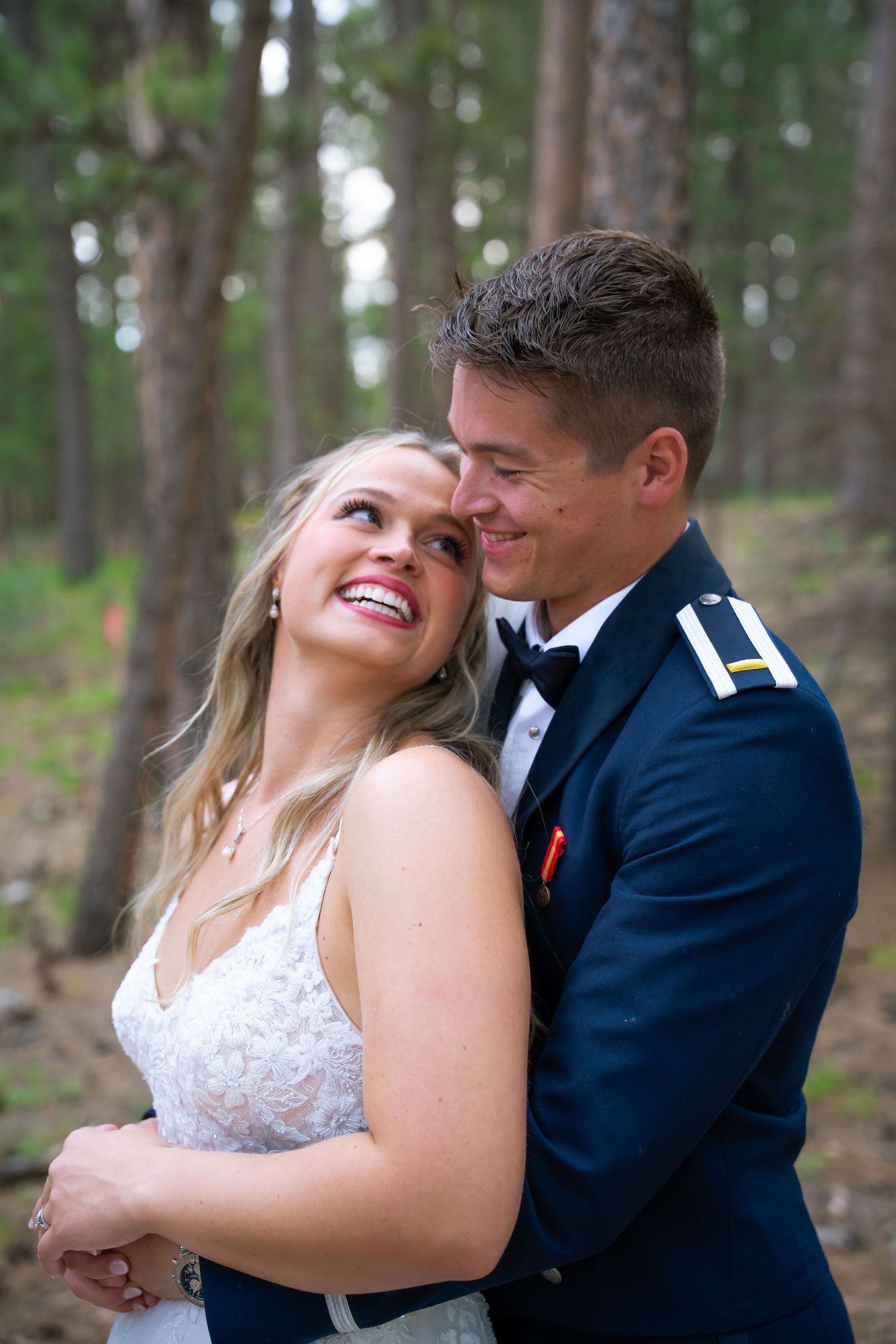 A couple shares a joyful moment together in the forest during their wedding photoshoot.