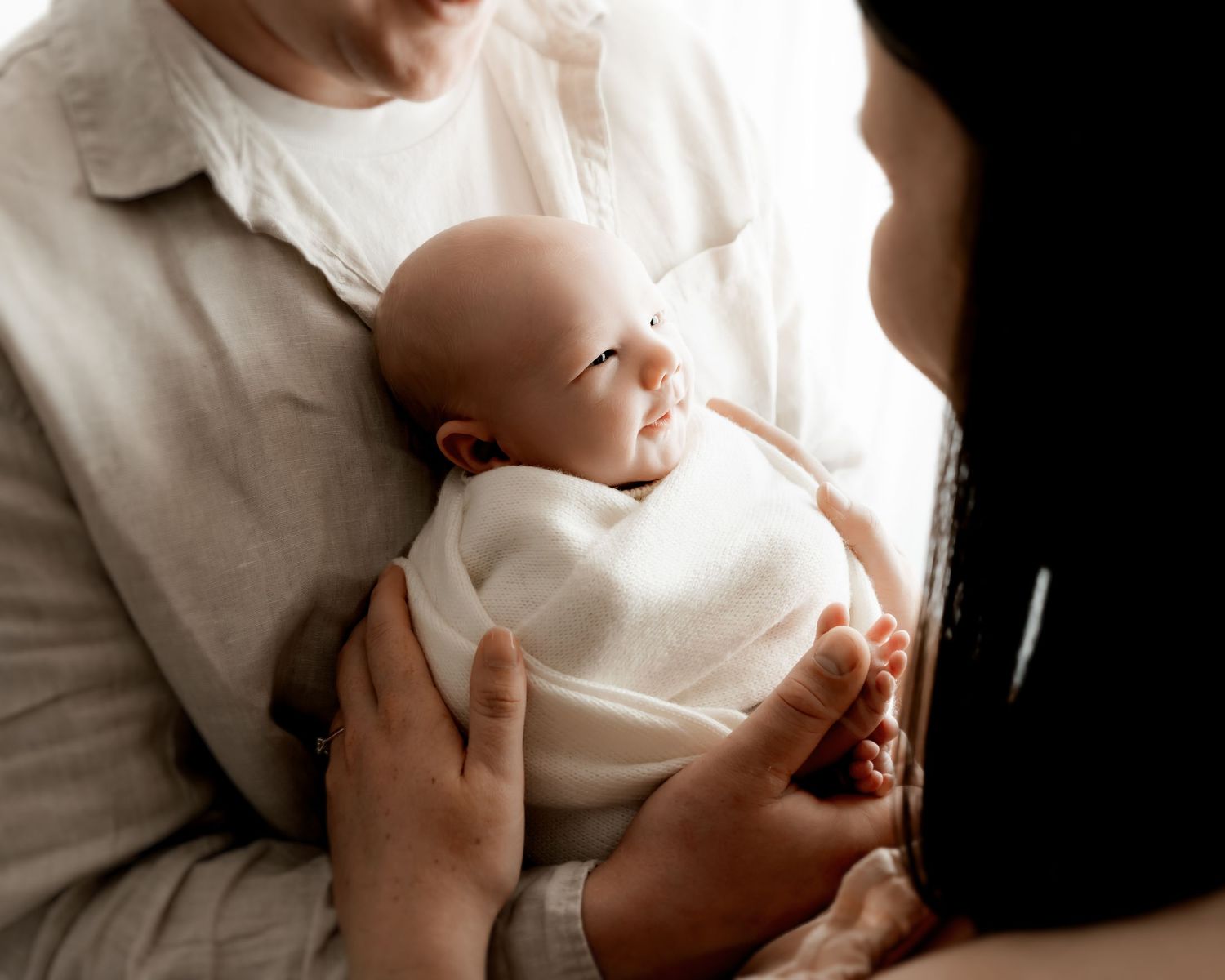 Mother holding newborn baby during family newborn portrait session