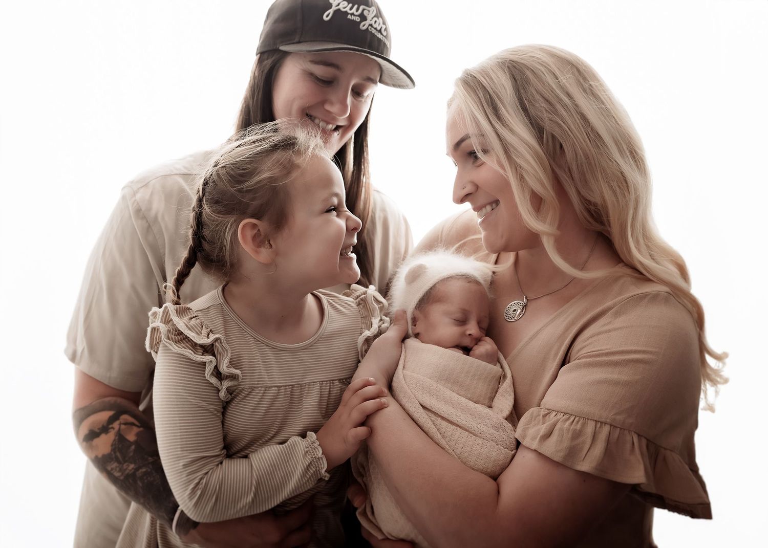 Family embracing during newborn photography session in Nelson
