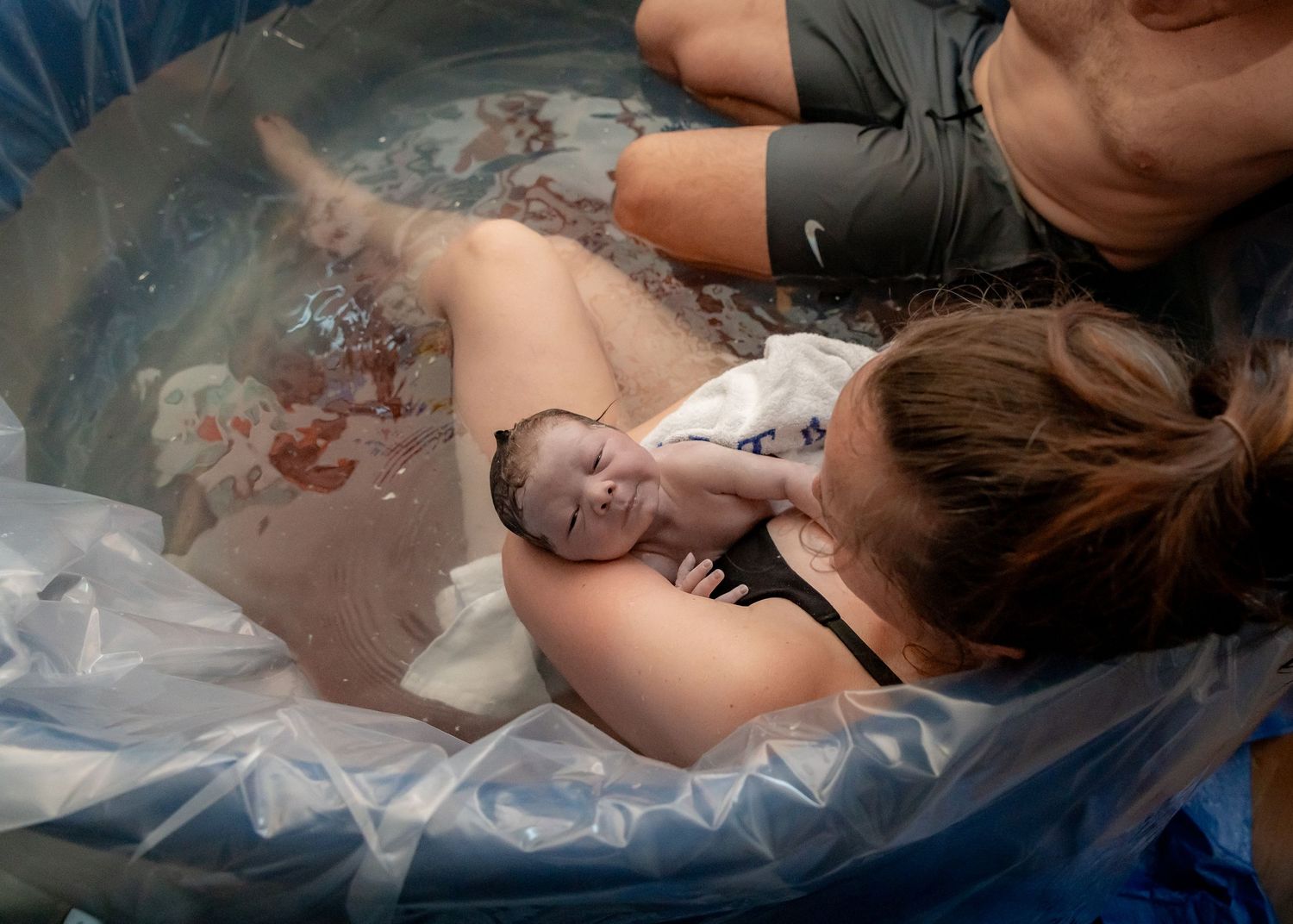 mother holding and gazing at her baby after home birth delivery in Nelson