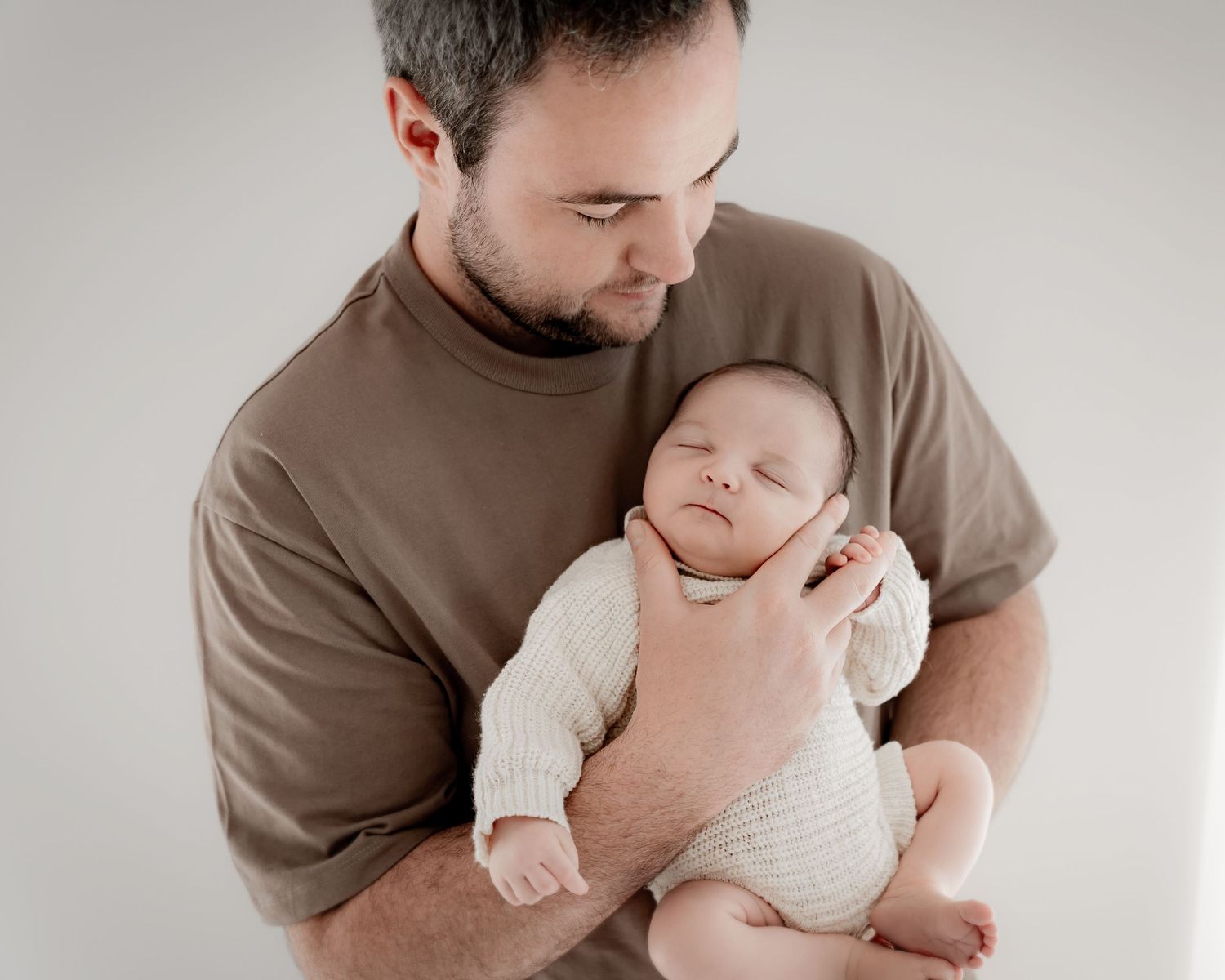 Father holding newborn baby during newborn photography session