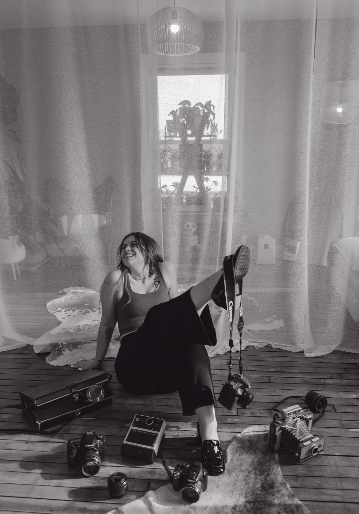 Black and white vintage photo of roller skates, music equipment and vintage decorations on wooden floor with sunlit window.