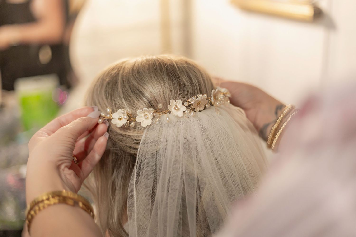 A close-up view of a bridal hairstyle with delicate floral hair accessories and pearl details.