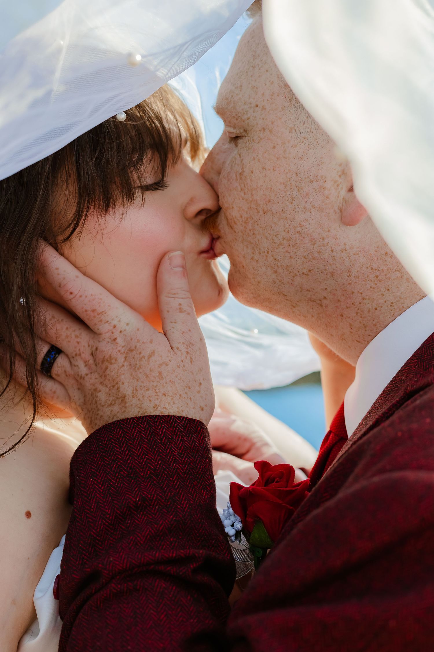 A romantic wedding kiss sequence showing five progressive closeup shots of a couple in burgundy and white attire.