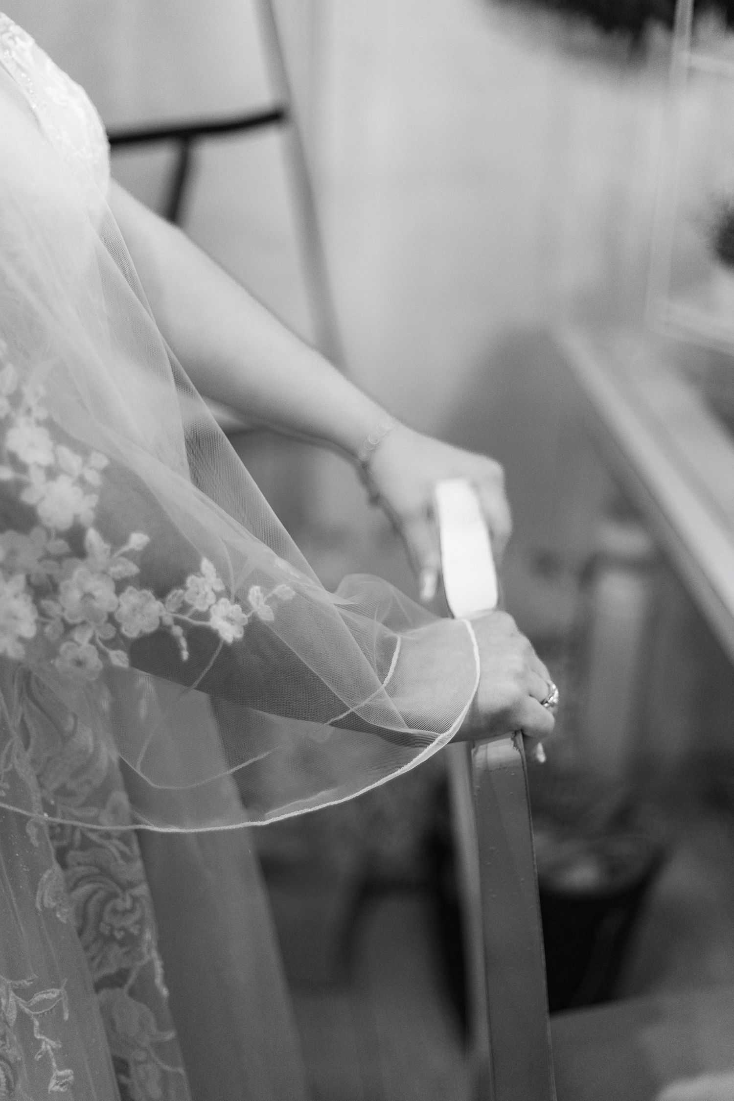Close-up black and white detail of lace wedding veil and dress.