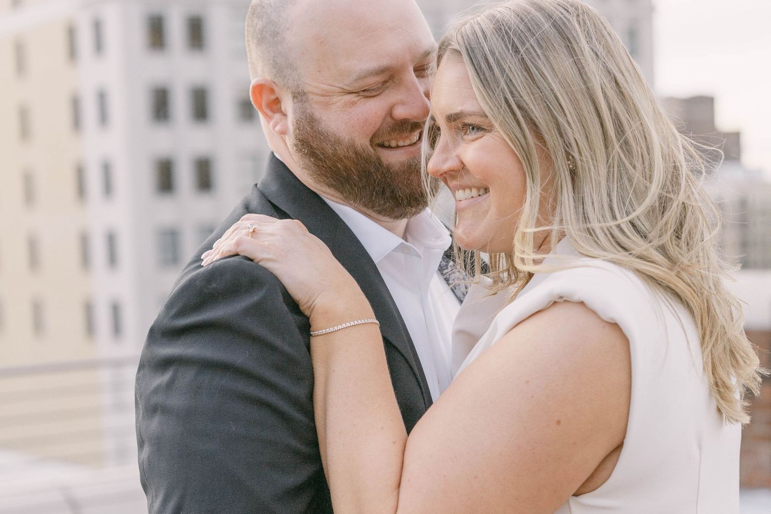 A romantic moment captured between a couple in formal attire sharing a tender moment outdoors.