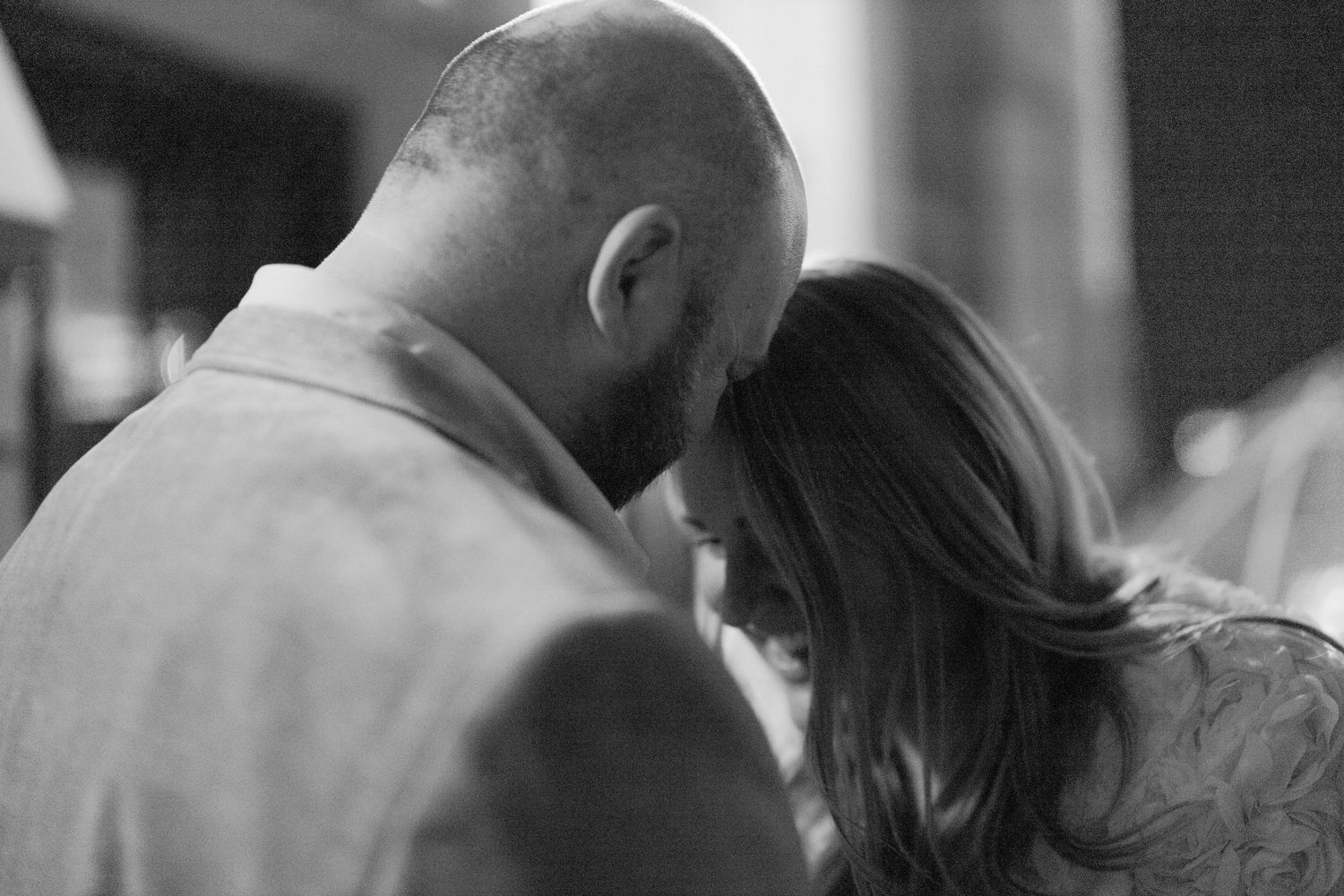 A couple shares an intimate black and white portrait while gazing into each others eyes in a romantic pose.