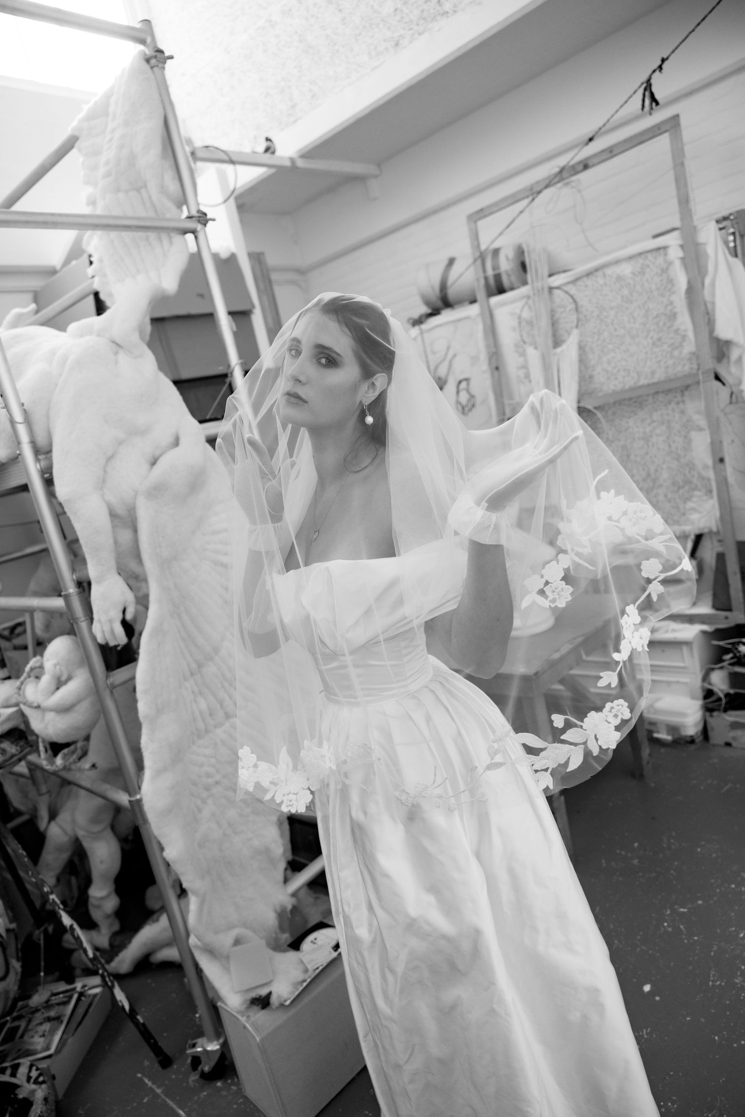 Black and white sequence showing wedding dresses hanging in preparation for a bridal event.
