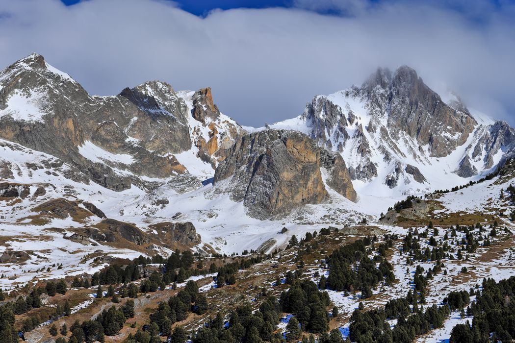 Le refuge de la Fournache humblement niché au pied des falaises minérales et enneigées de la majestueuse Dent Parrachée en Vanoise.
