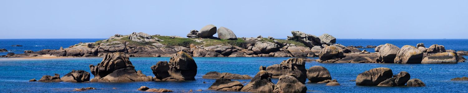 Panorama de l'Île aux Lapins sur la Côte de Granit Rose. Rochers sculptés, eau turquoise et mer profonde sous un ciel pur.