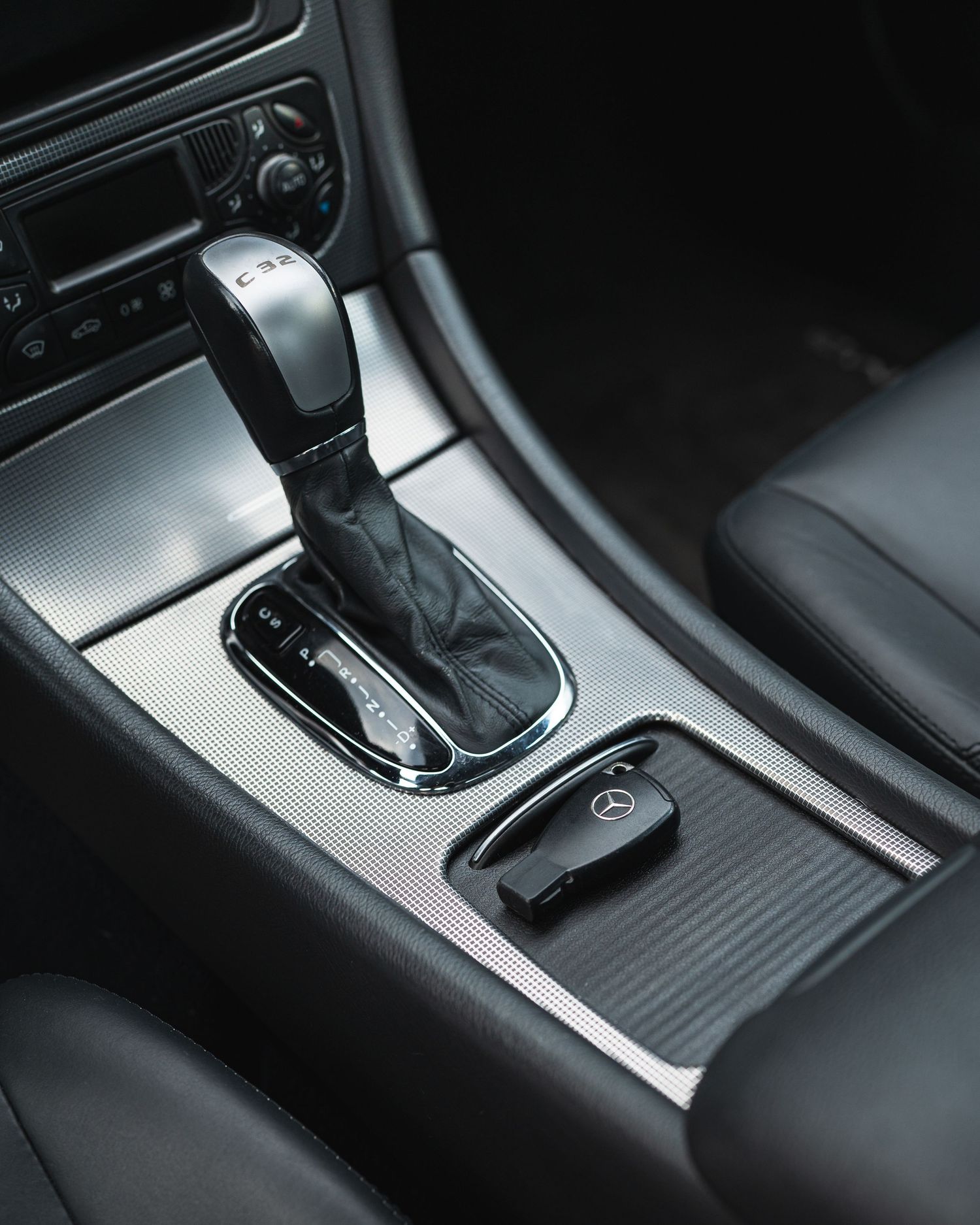 The gear shift and center console of the 2004 C32 AMG in the Anthracite colorway.