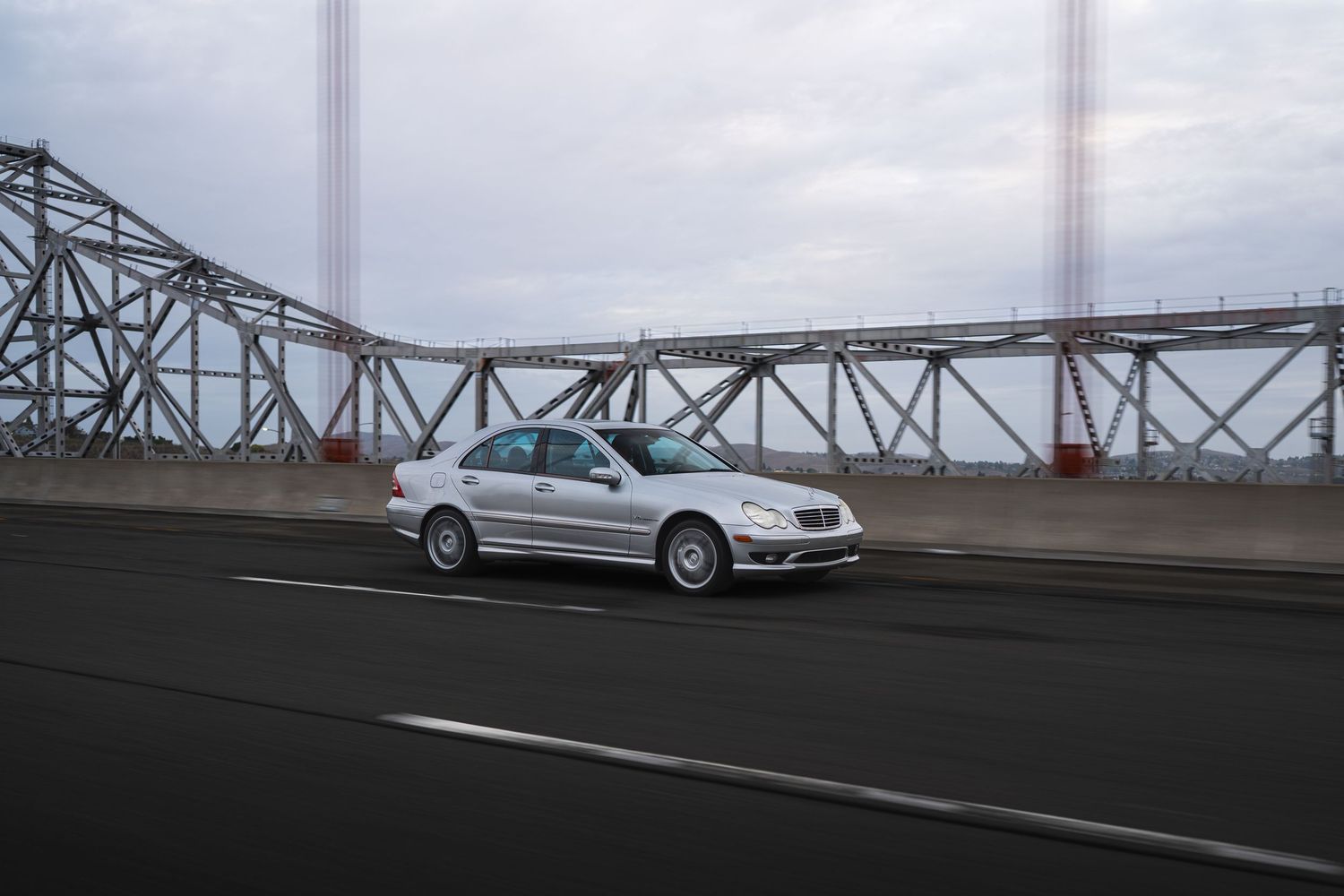 Mercedes-Benz C32 driving across the Alfred Zampa Memorial Bridge bridge with during a cloudy morning.