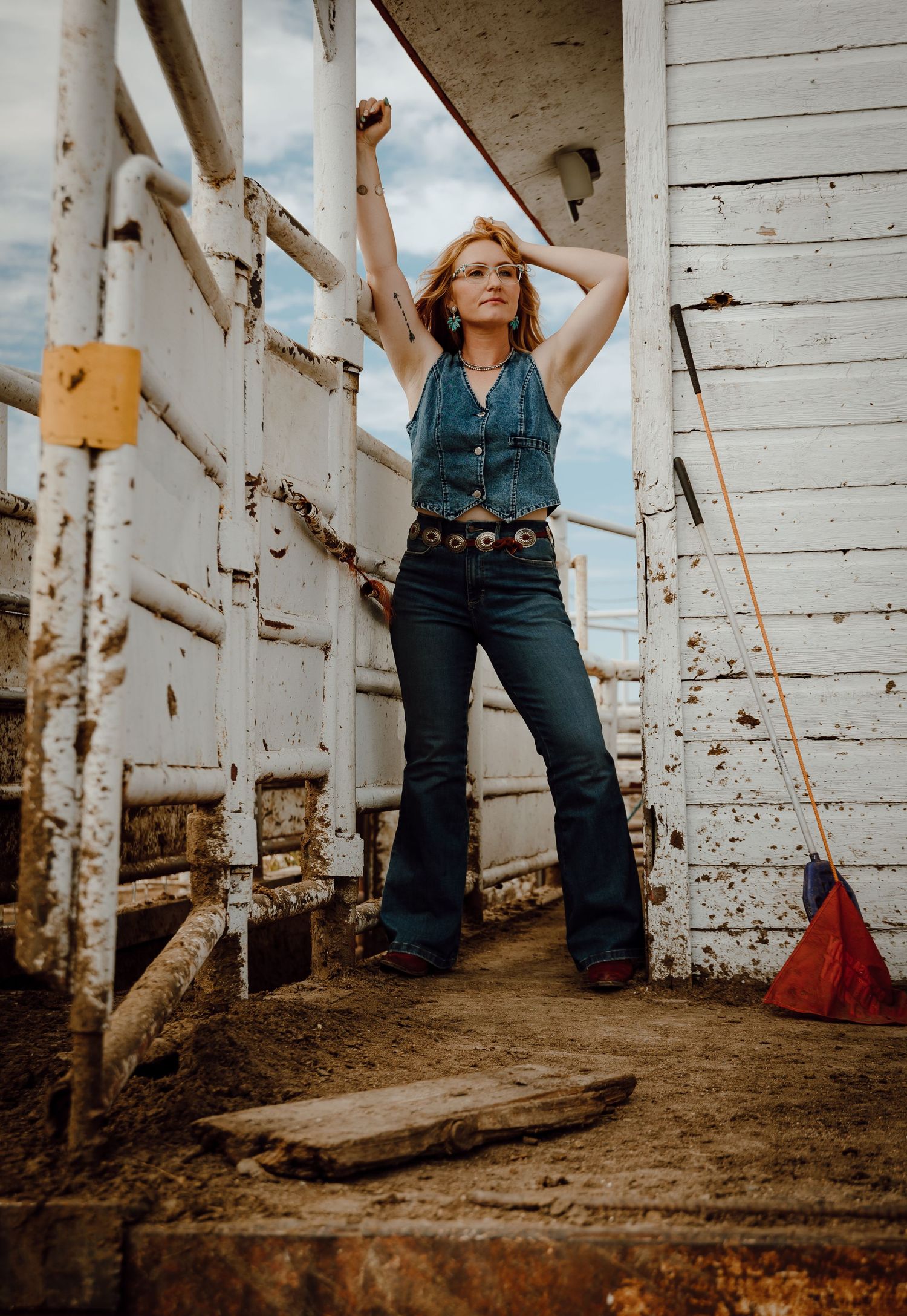 A North Platte, Nebraska lifestyle session woman models on a white painted loading dock at a stockyard.