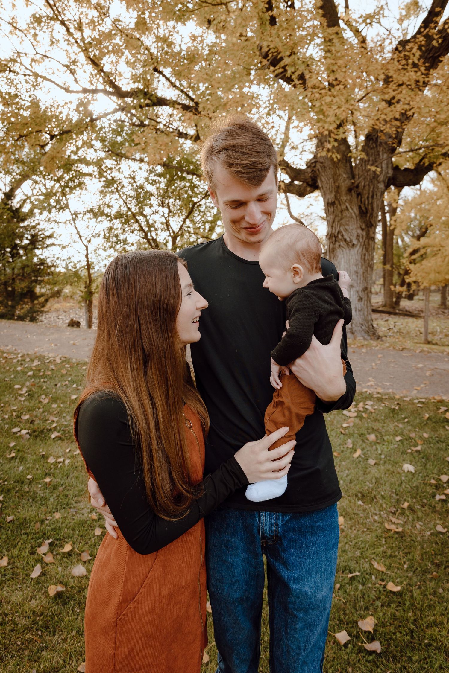 A North Platte, Nebraska lifestyle family session family shares joyful moments together in a park with golden leaves.