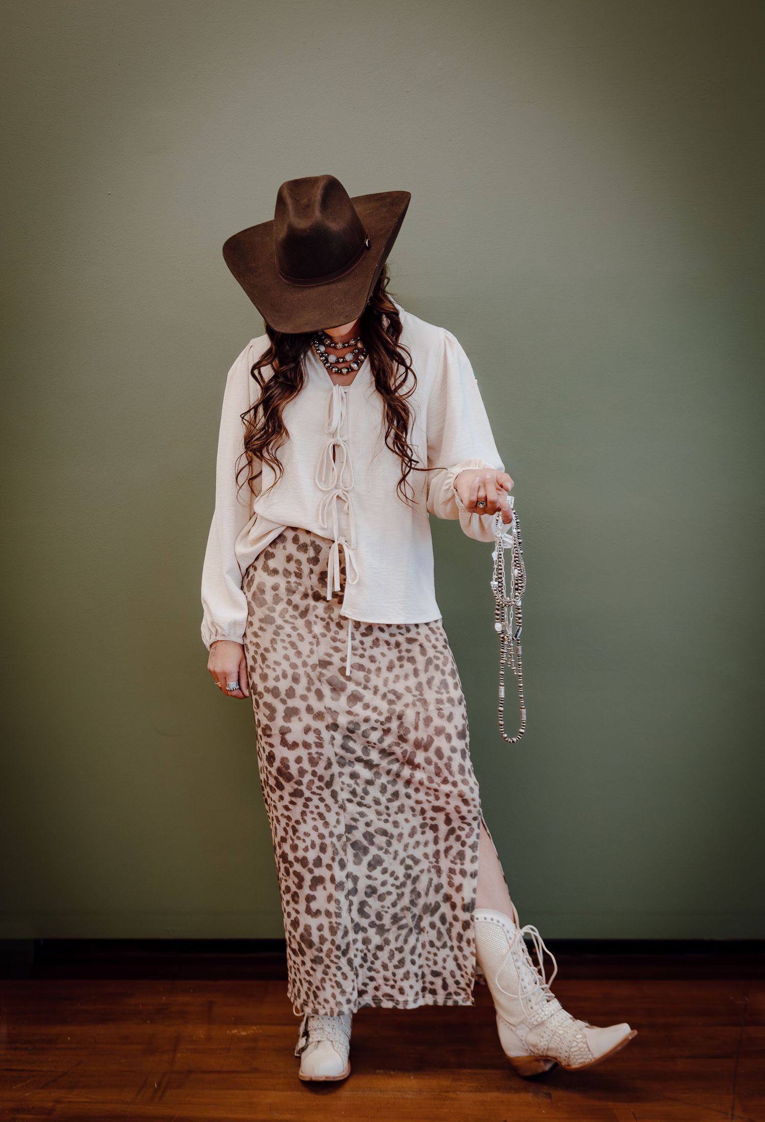 A North Platte, Nebraska lifestyle brand session woman models jewelry in western attire.