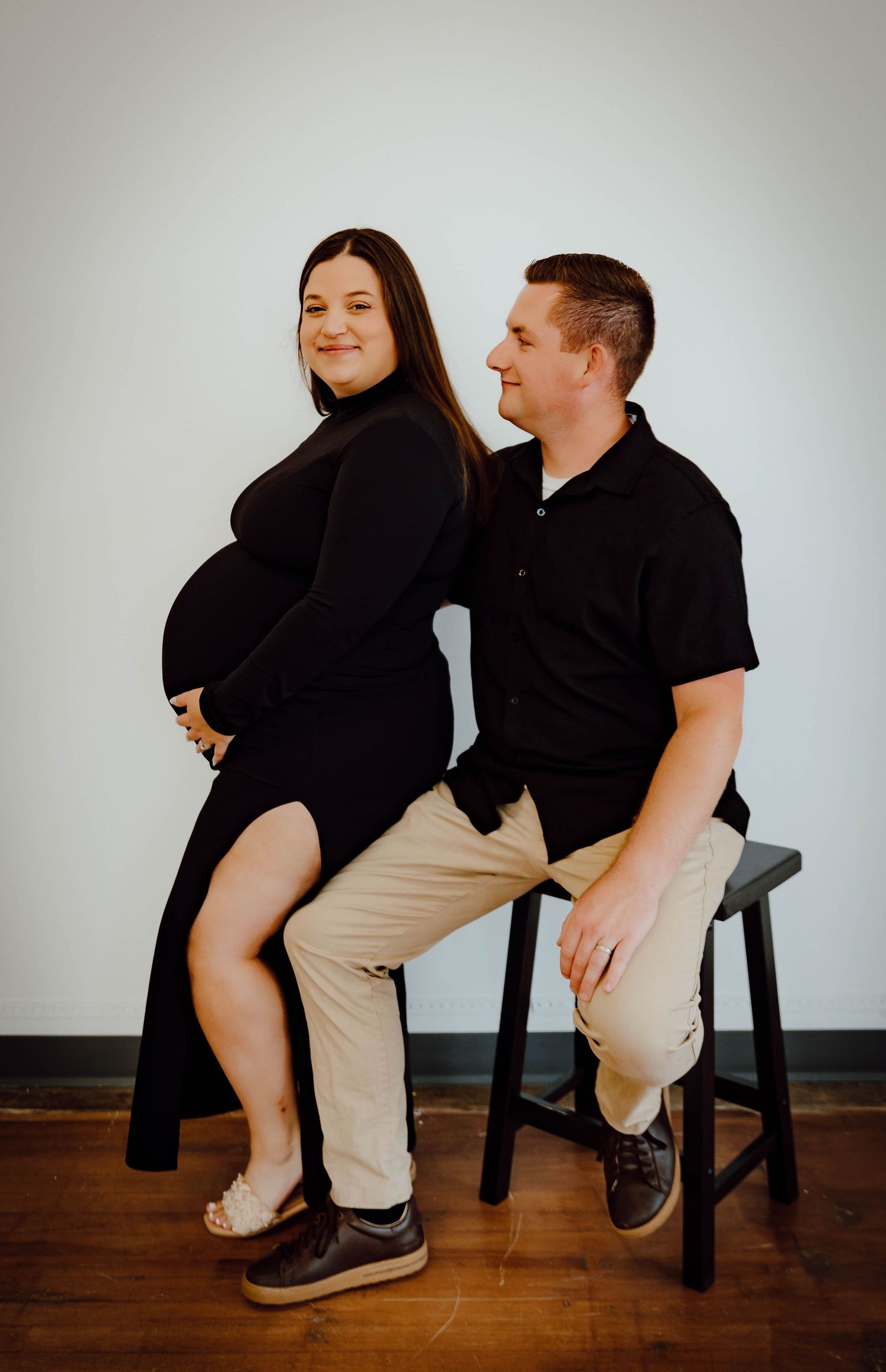 A North Platte, Nebraska lifestyle maternity session couple interacting together in studio.