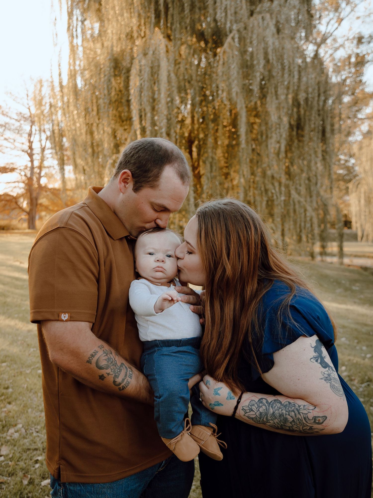 A North Platte, Nebraska lifestyle family session family shares tender moments together in a wooded outdoor setting during golden hour.