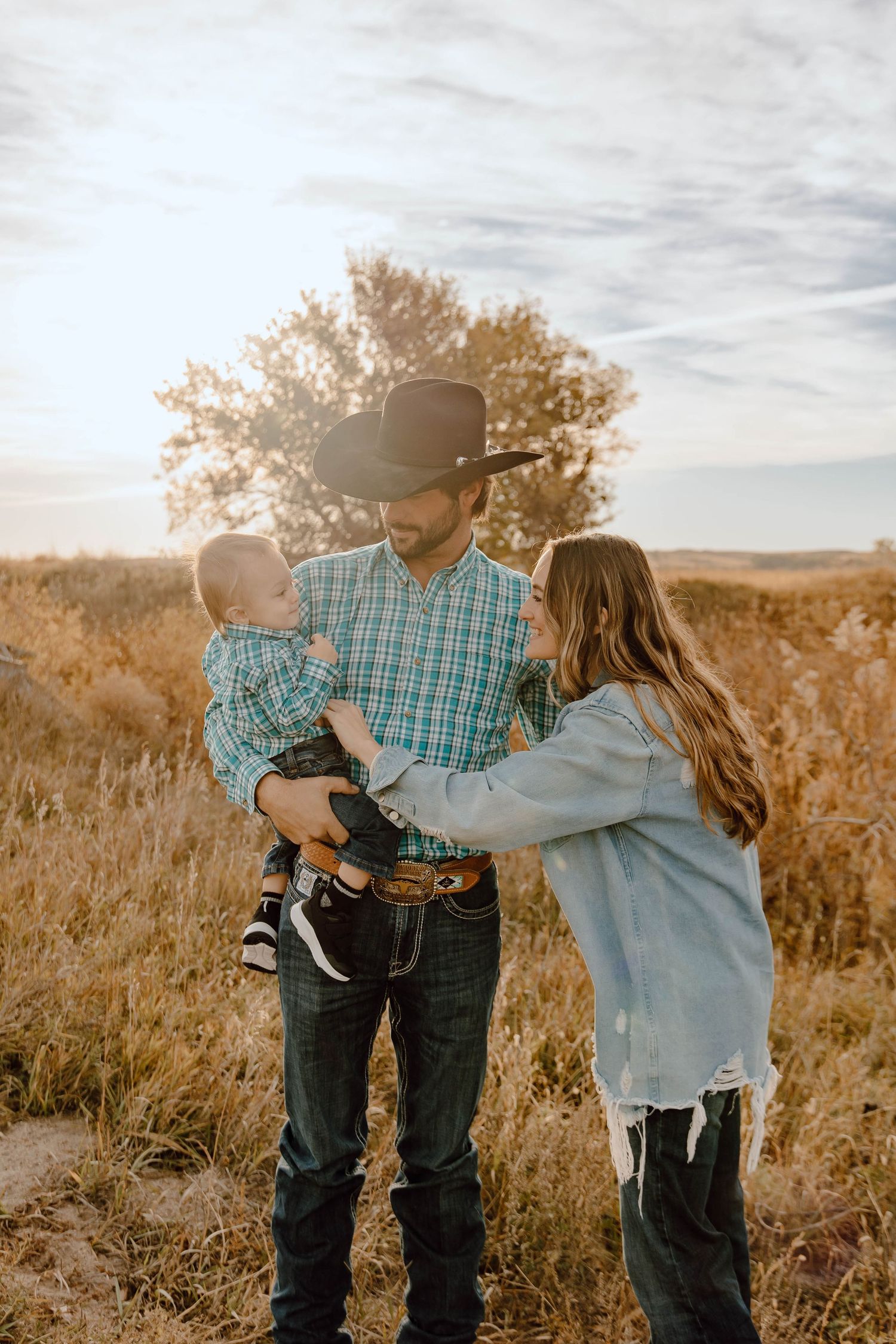 A Sutherland, Nebraska family lifestyle session family sharing tender moments together in a golden field at sunrise.