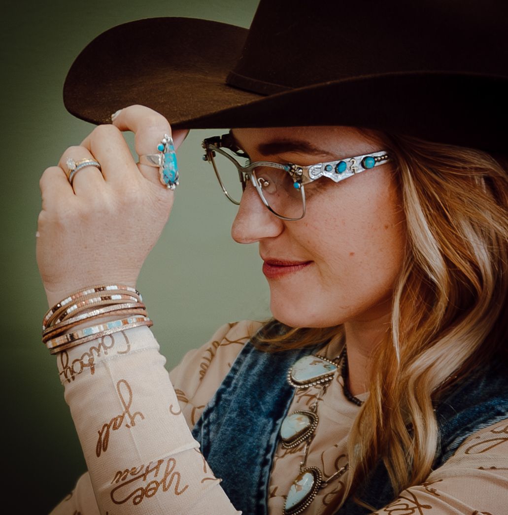 A North Platte, Nebraska lifestyle brand session woman in a brown cowboy hat and glasses with red hair wearing western-style attire.