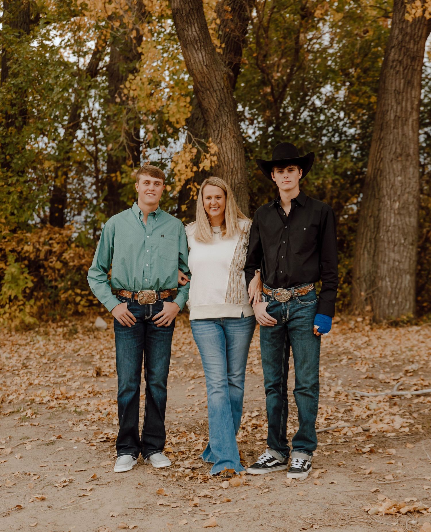 A Sutherland, Nebraska lifestyle family session mom and her son's standing together on fallen autumn leaves in casual attire.