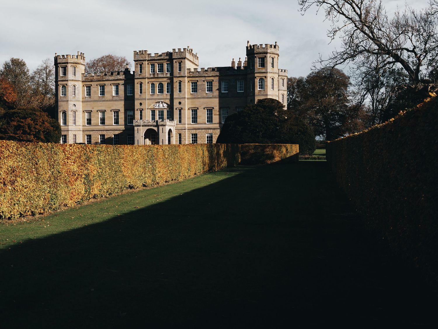 Wedderburn Castle amid autumn foliage at dusk.