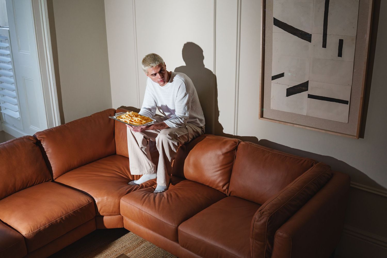 Interior view of a modern living room with natural light streaming through windows. For Superba