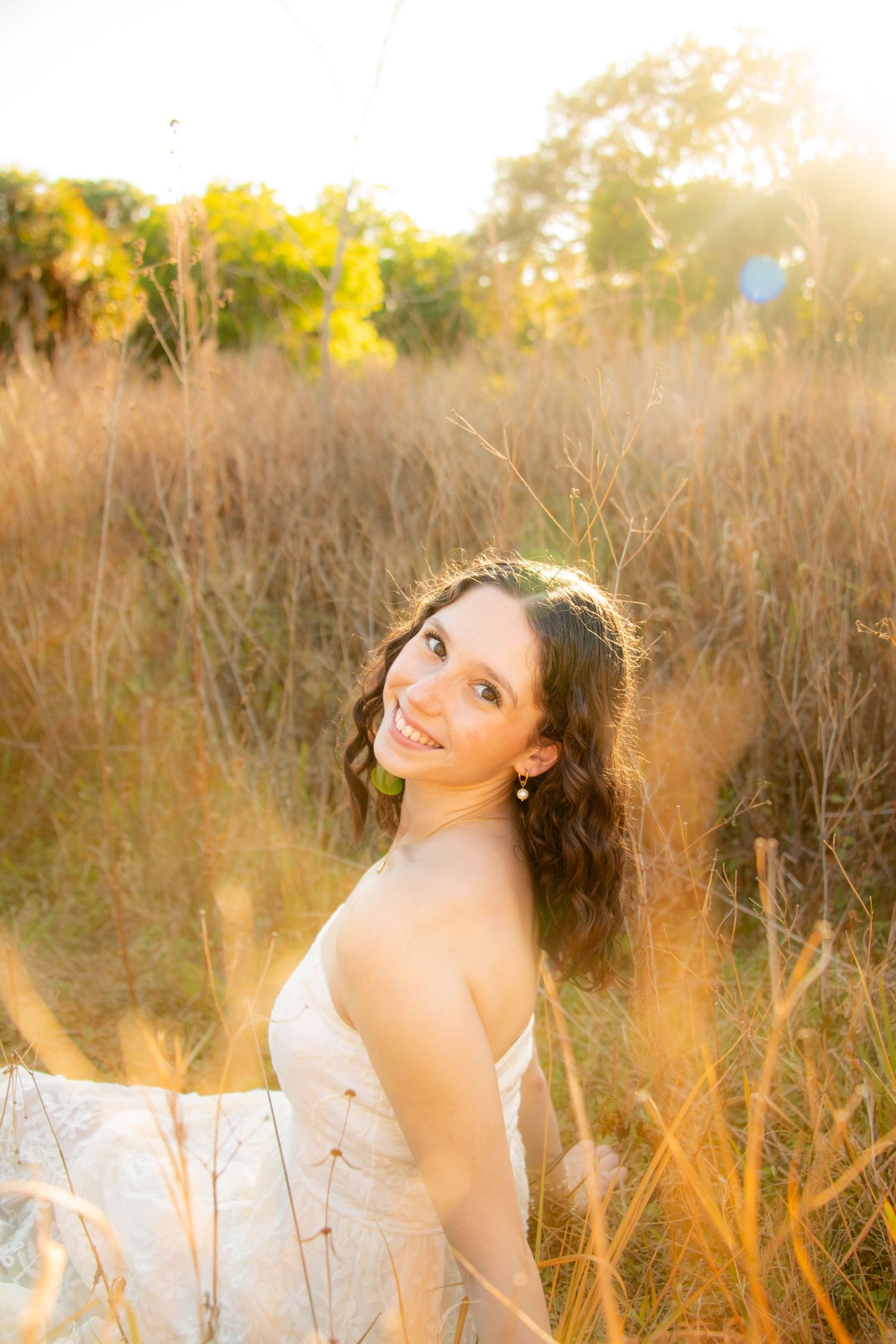A dreamy portrait series in a golden field at sunset with soft natural lighting and tall grass.