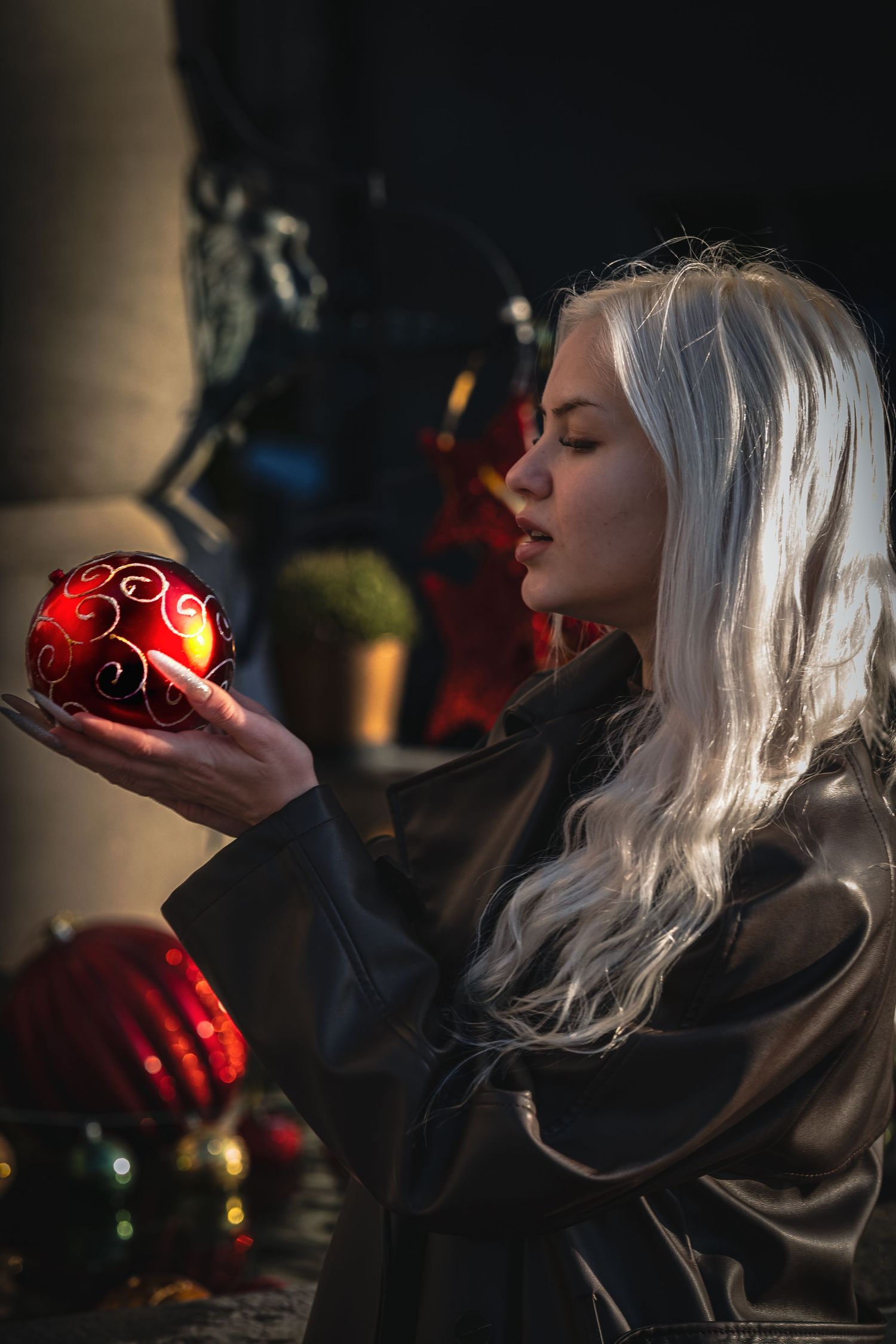 A series of moody photos showing someone with white hair holding illuminated red objects in dark atmospheric lighting.