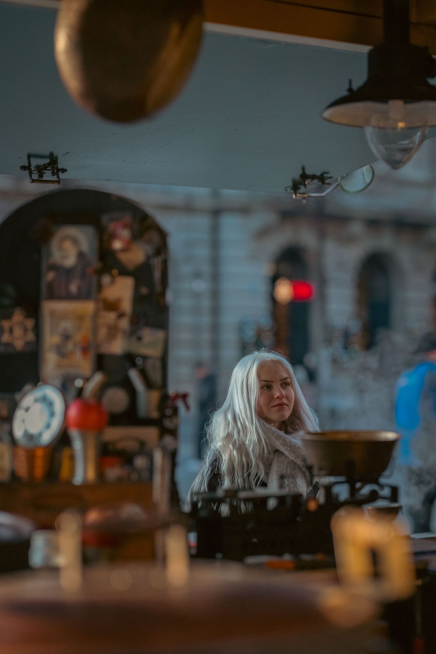 A dimly lit bar or restaurant interior with hanging lights and blurred background creates a cozy ambiance.