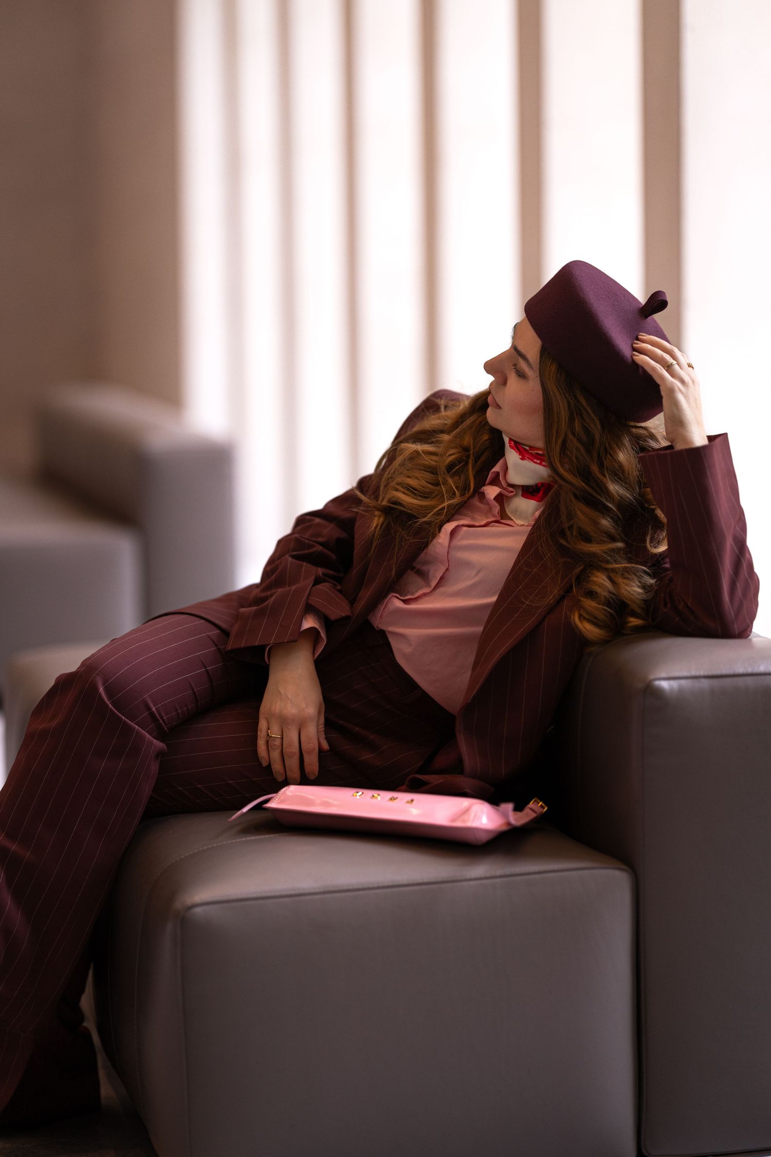 Person in burgundy hoodie lounges on dark couch in dramatic lighting sequence showing progressive reclining positions.