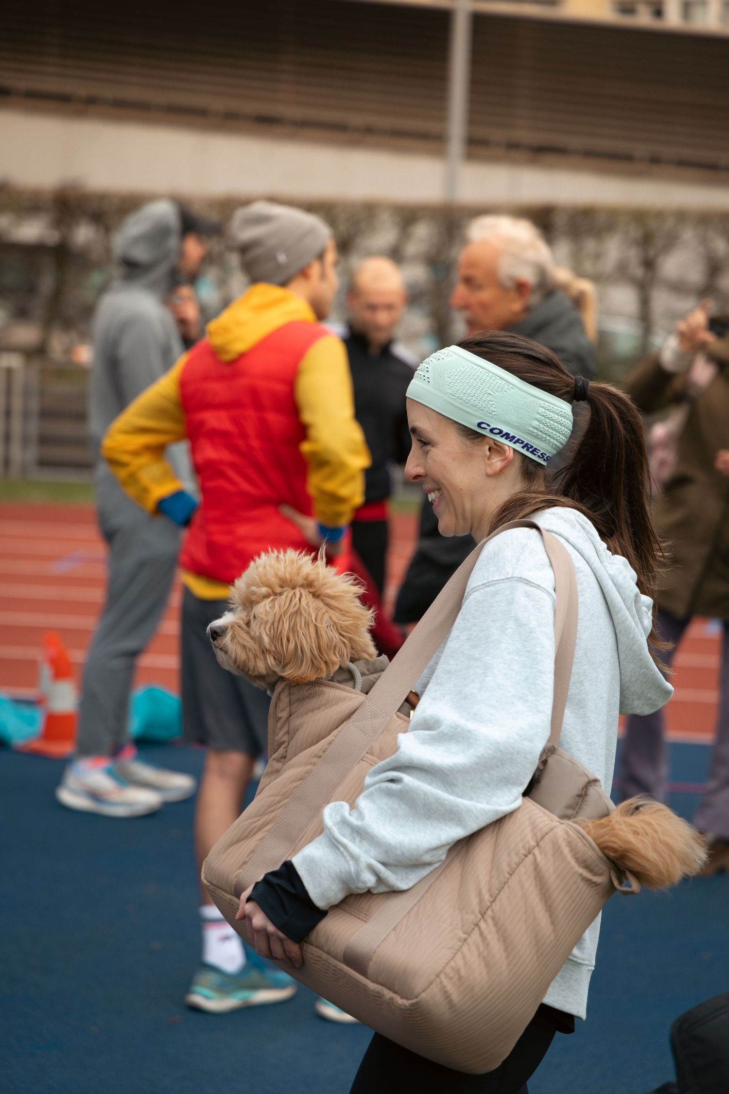 People embracing and celebrating on an outdoor track during athletic event.