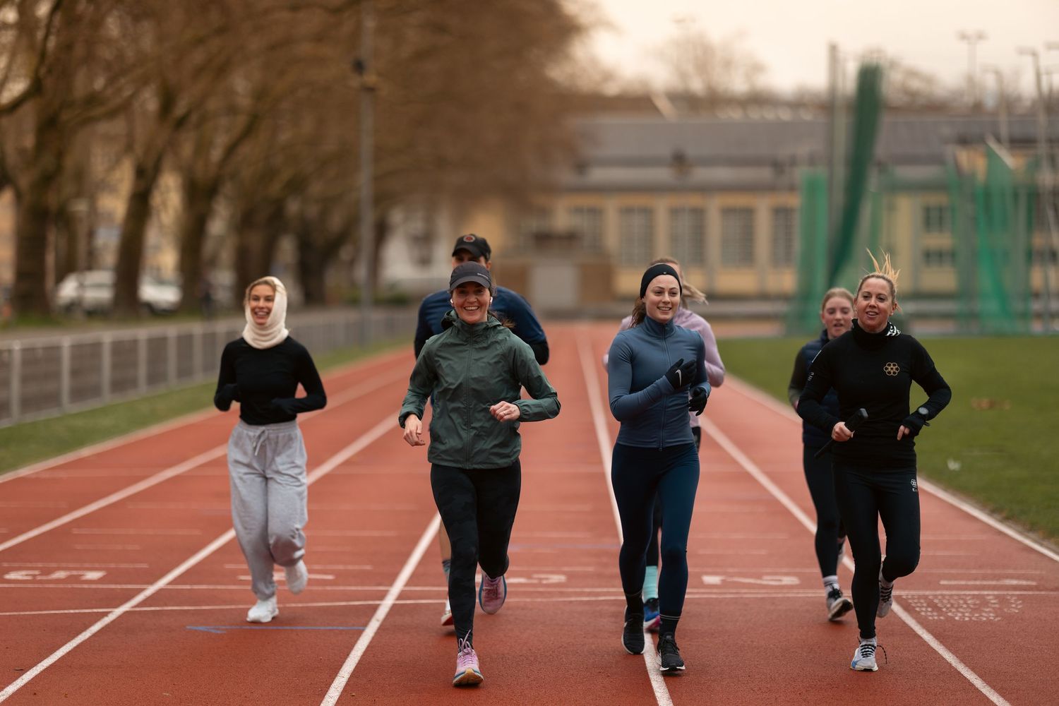 Athletes training together on a running track during a group workout session.