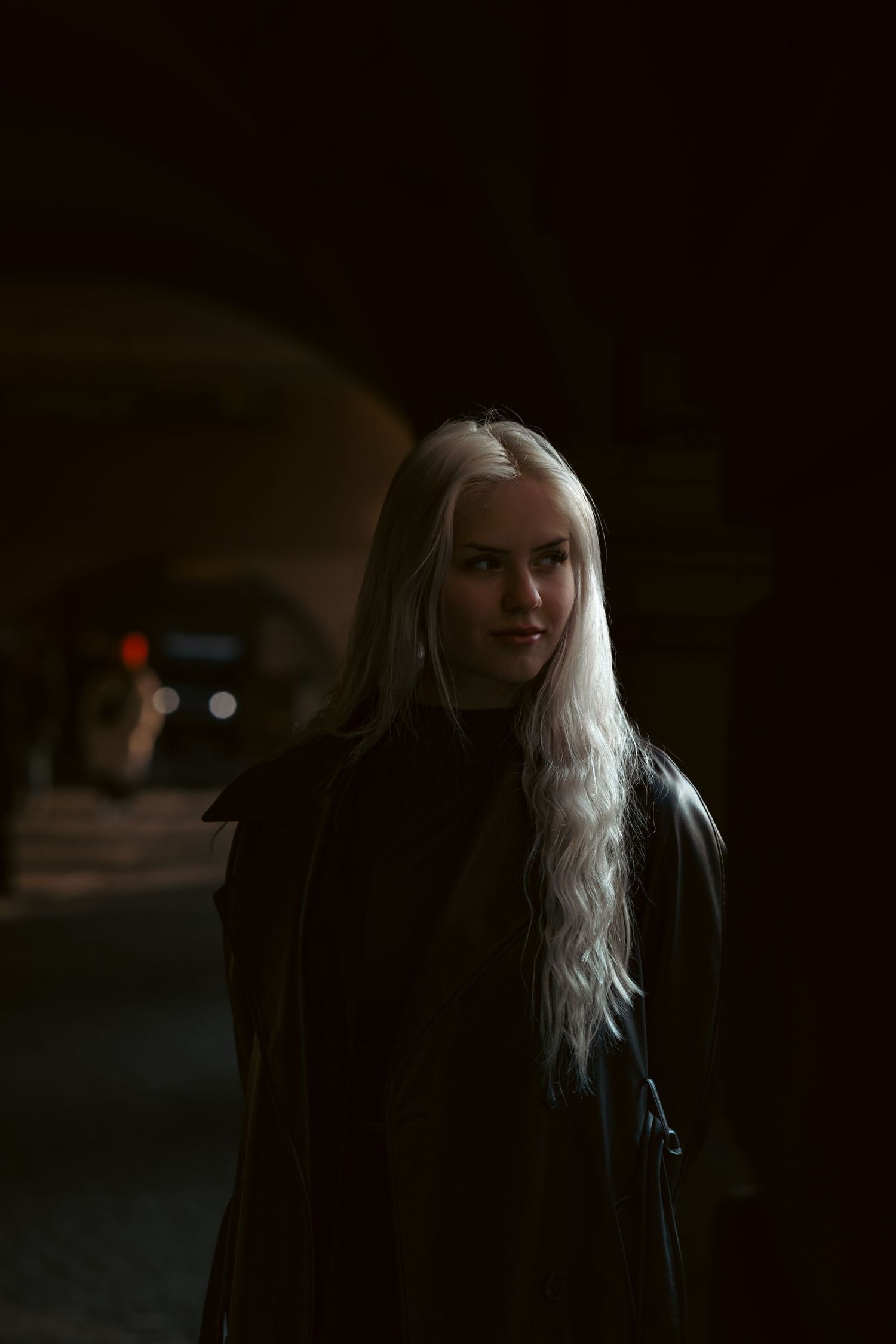 Dramatic nighttime portrait featuring long white hair and dark clothing in low light setting.
