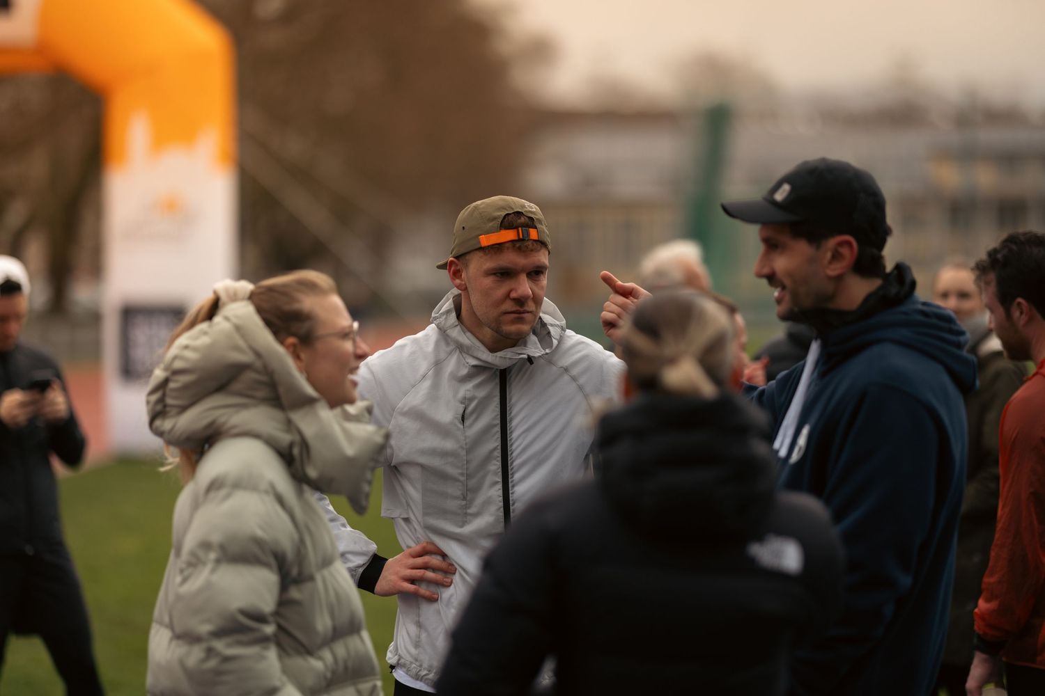 Group of runners gathered for discussion during outdoor training session.