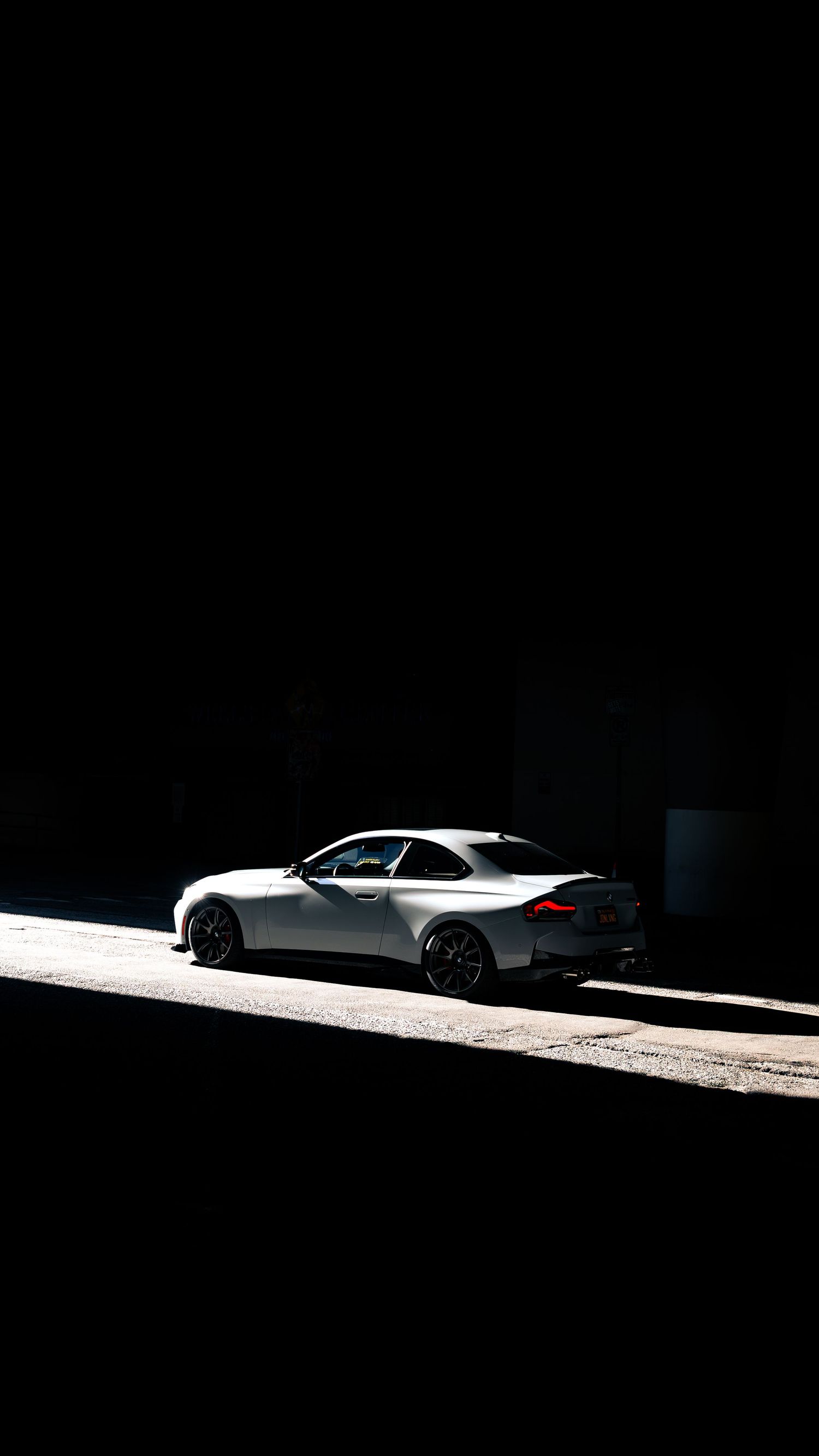 BMW M series car photographed in dramatic shadows and natural light.
