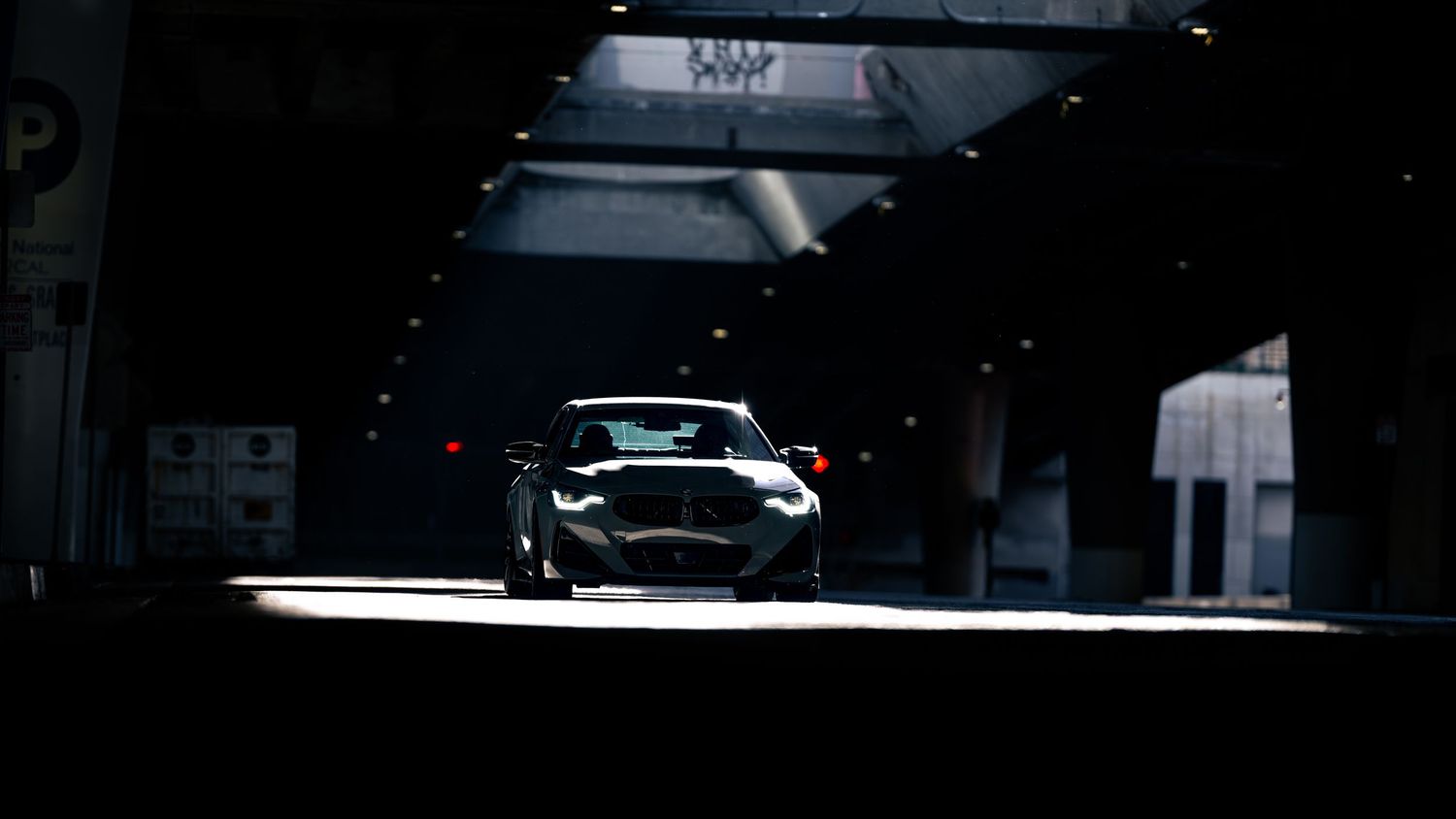 Side profile of a lowered sports car with aftermarket wheels in moody lighting.