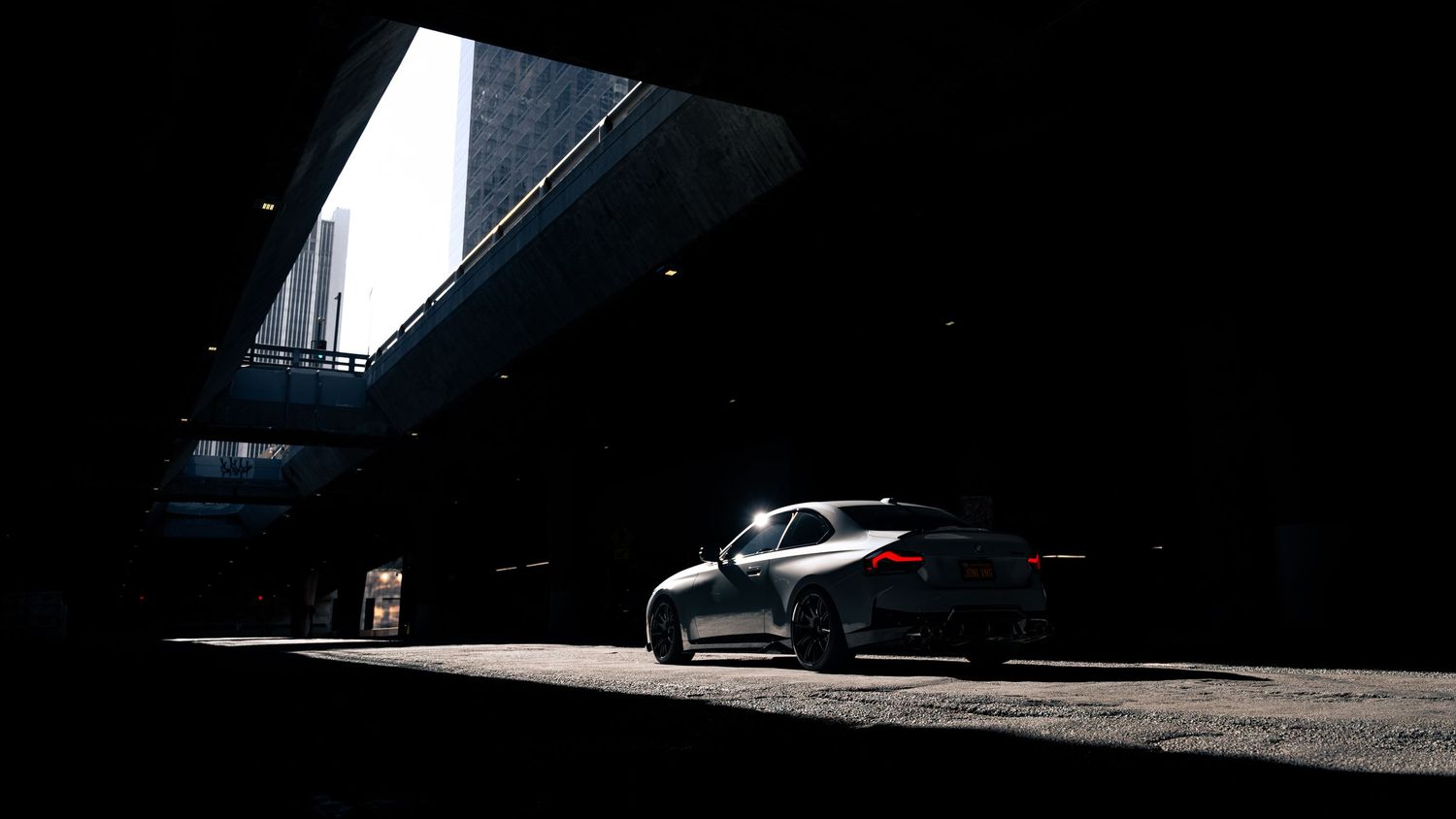 Dramatic low-key lighting on performance vehicles in an indoor setting.