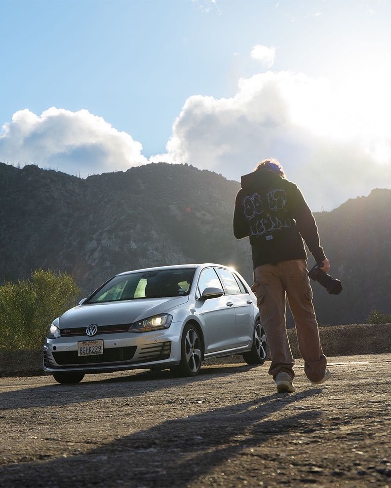 Silver Volkswagen Golf photographed in mountain setting during sunset.