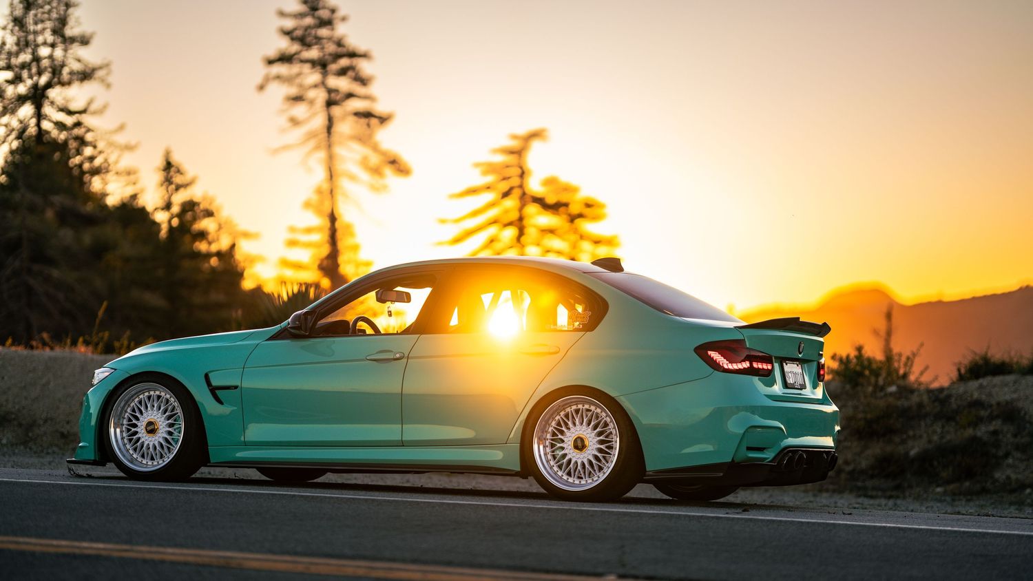 Low-angle profile shots of modified BMW M3 in turquoise color during golden hour.