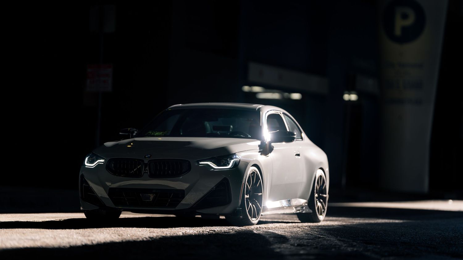 Custom sports car with performance modifications captured in dramatic shadows.